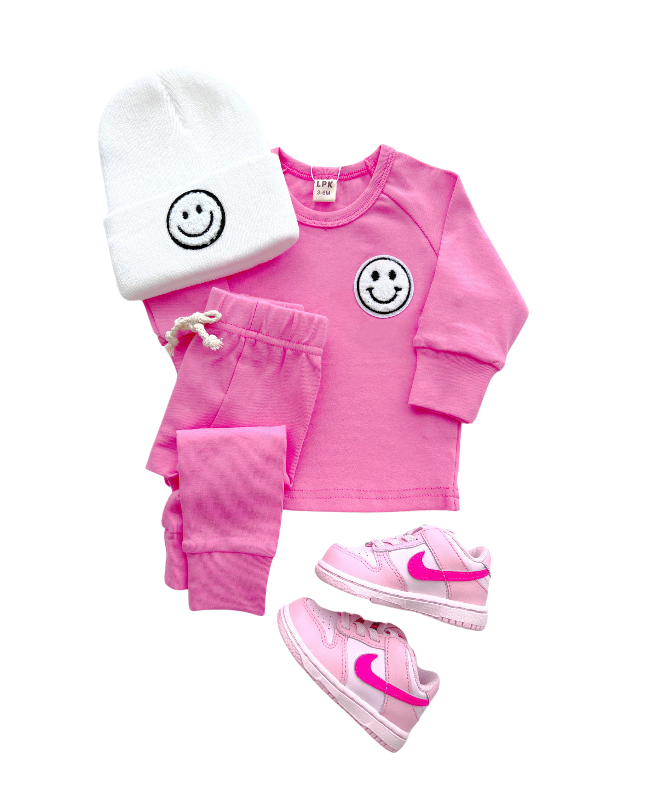 Lounge set smiley bubble gum for girls, featuring a pink tee, matching pants, beanie, and pink Nike shoes.