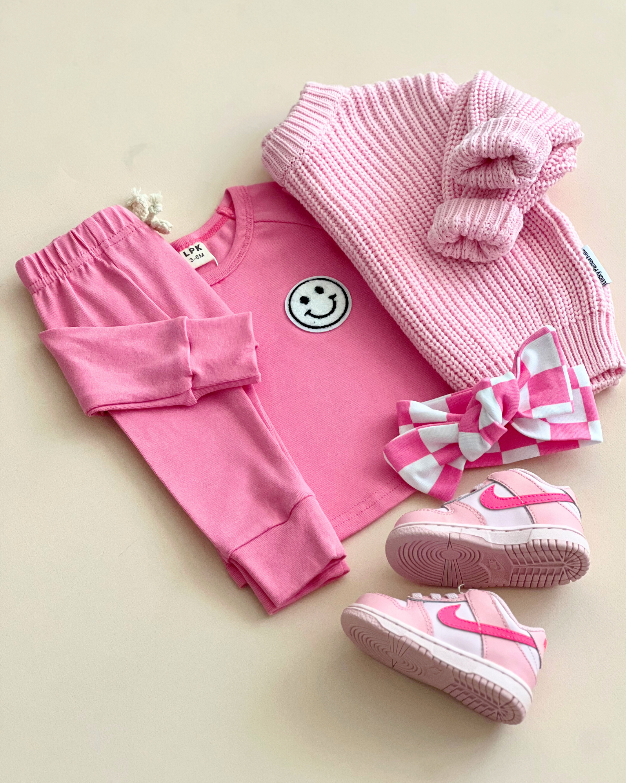 Lounge set smiley bubble gum with pink top, pants, bow, and sneakers for girls.