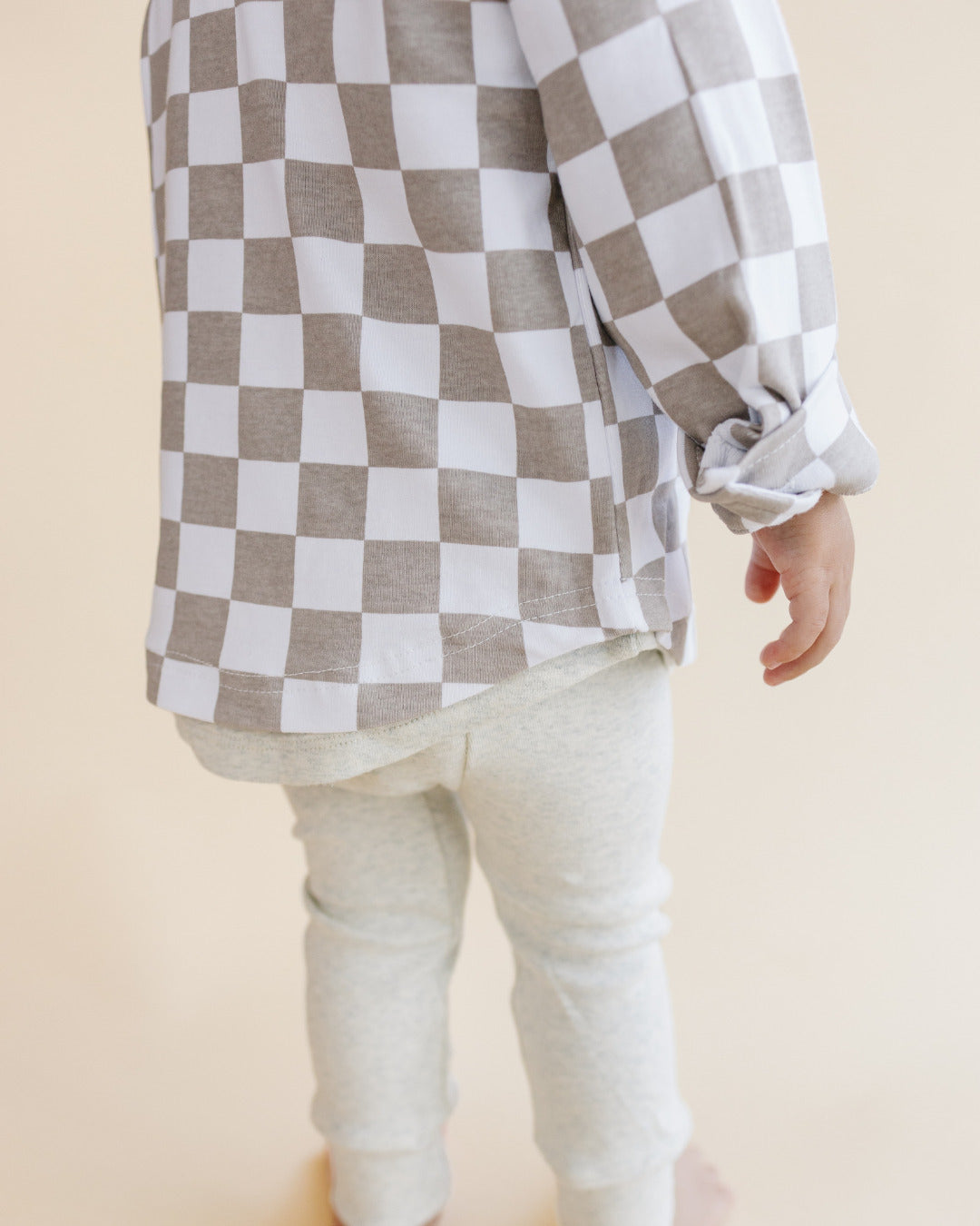 Child wearing a Cotton Shacket in Smiley Checkered Latte pattern with light-colored pants.