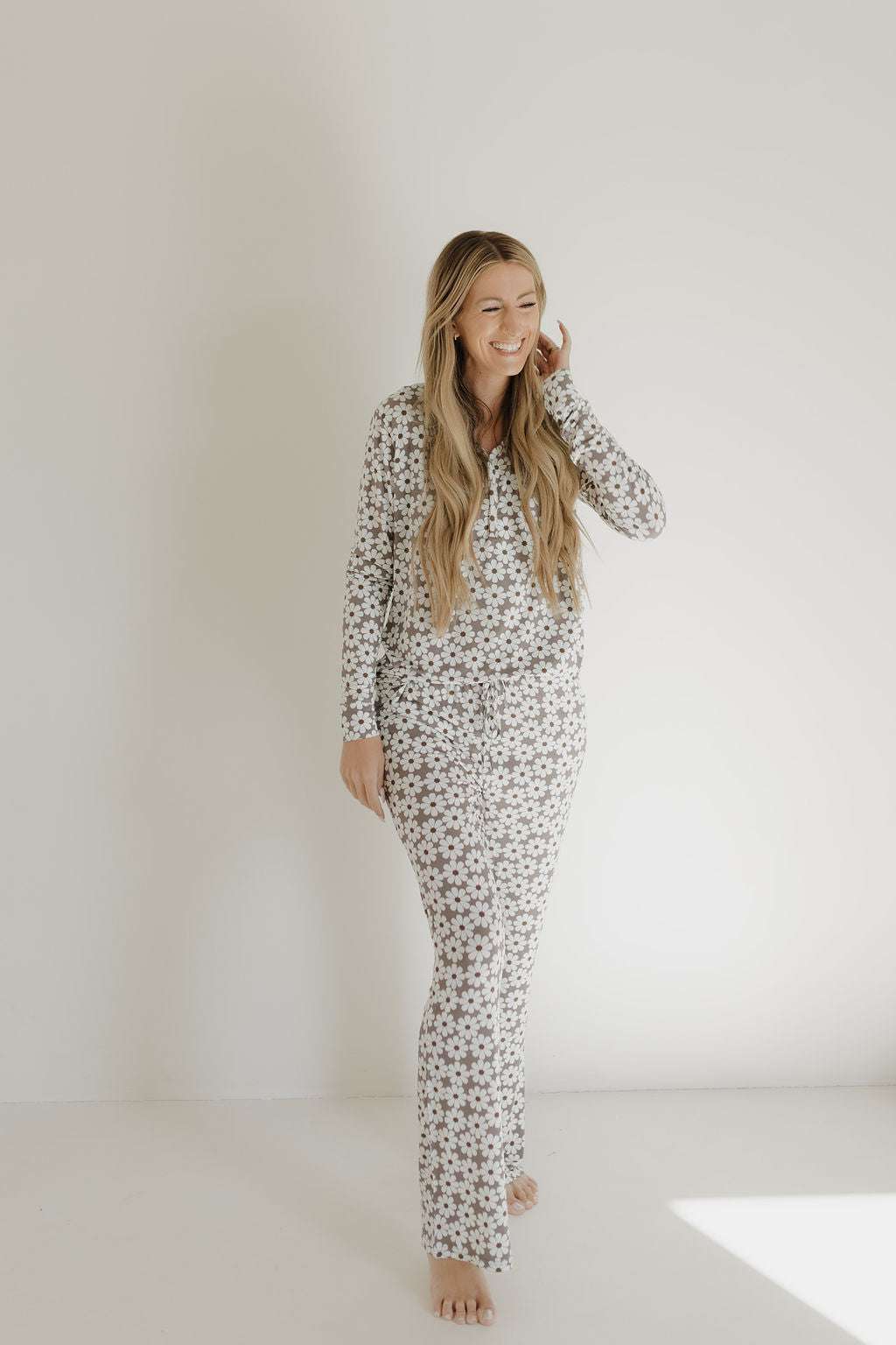 Woman smiling in womens bamboo pajama darlin' set with floral pattern, showcasing comfort and style.