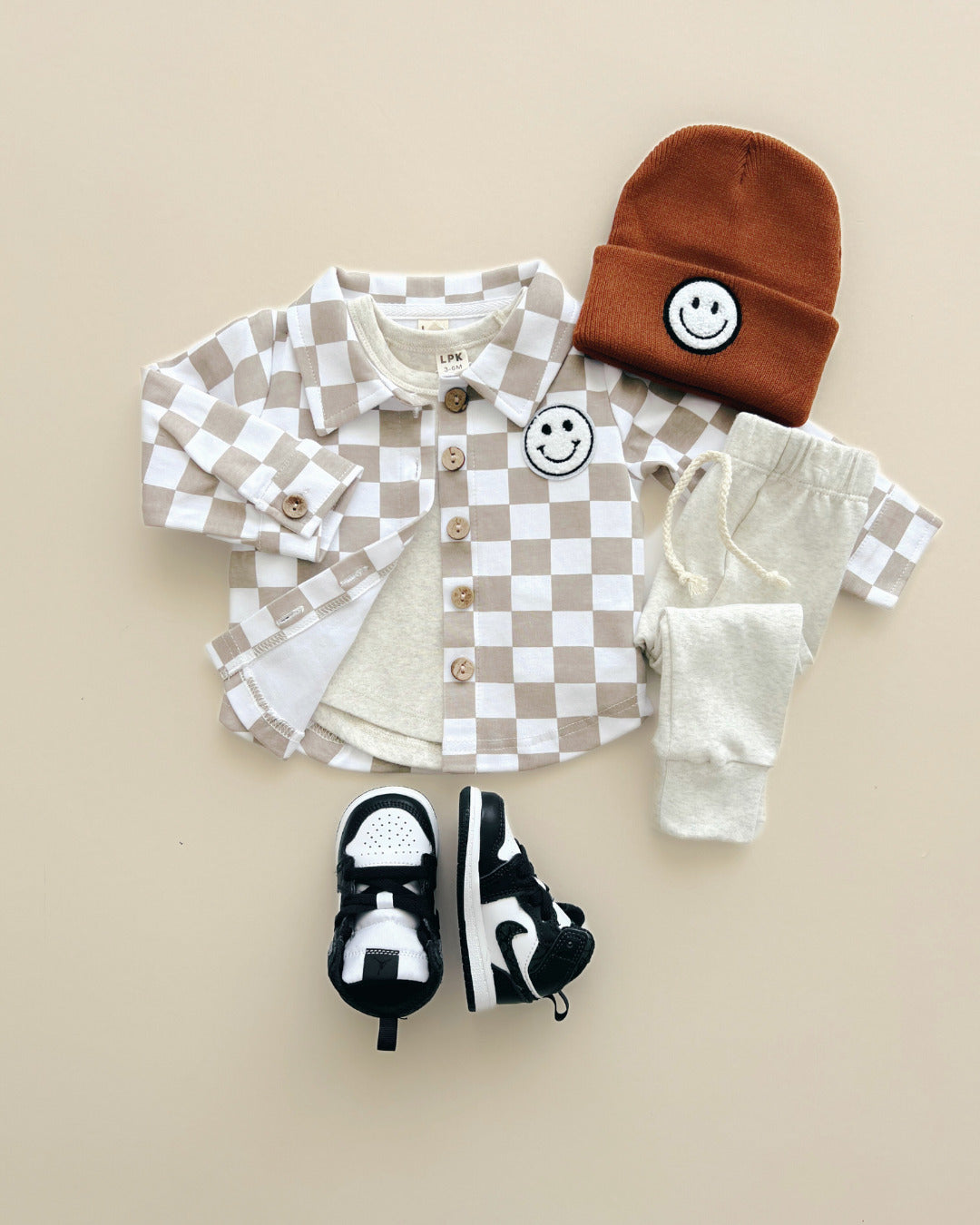 Cotton Shacket in Smiley Checkered Latte style, featuring button-down, smiley patch, and coordinating accessories for kids.