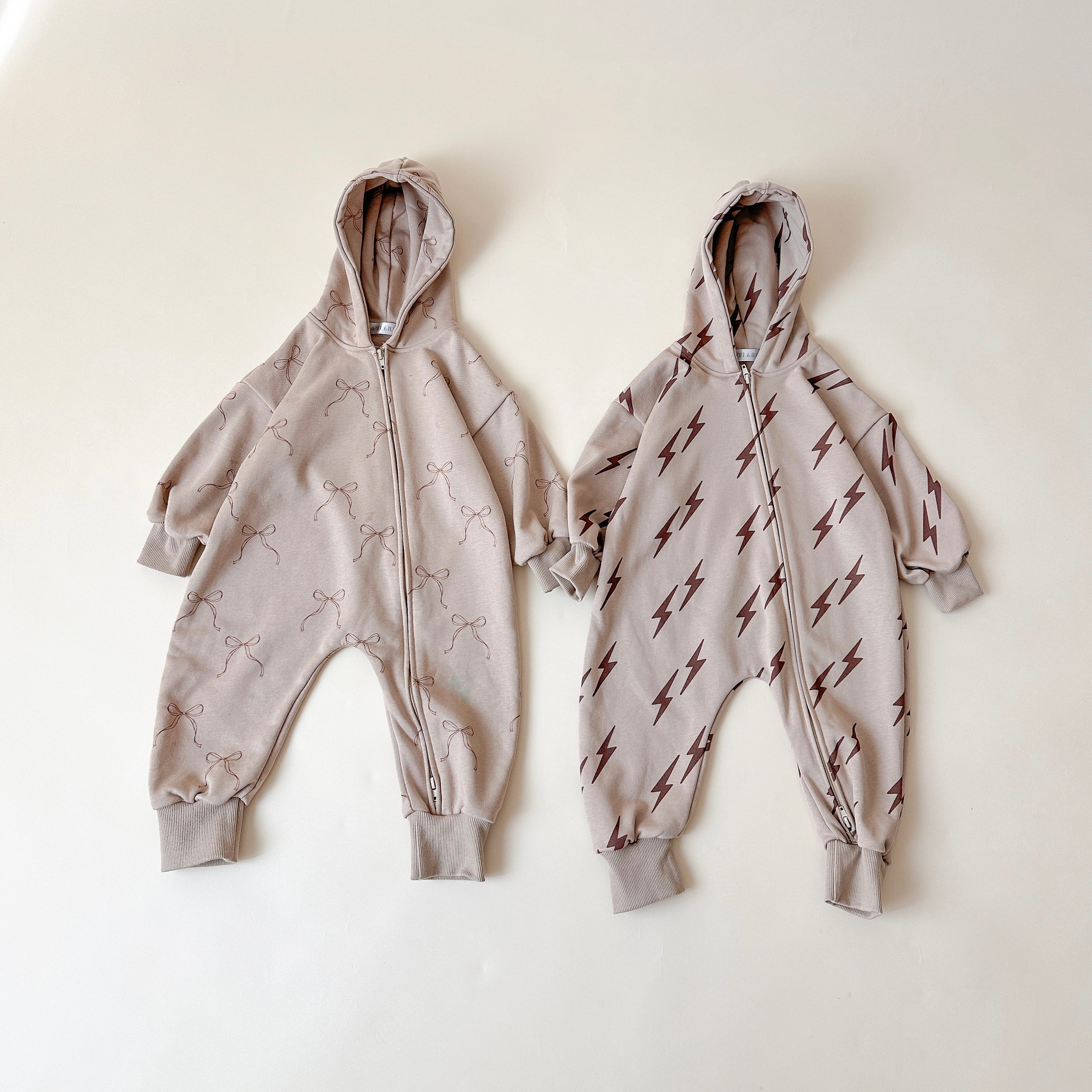 Kids zip jumpsuit set featuring bows for girls and lightning bolts for boys, perfect for cool weather layering.
