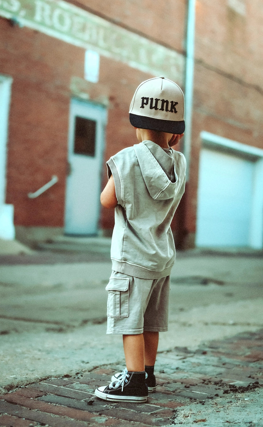 Kids wearing tan acid wash cargo shorts and a punk hat, ready for adventure in a stylish urban setting.