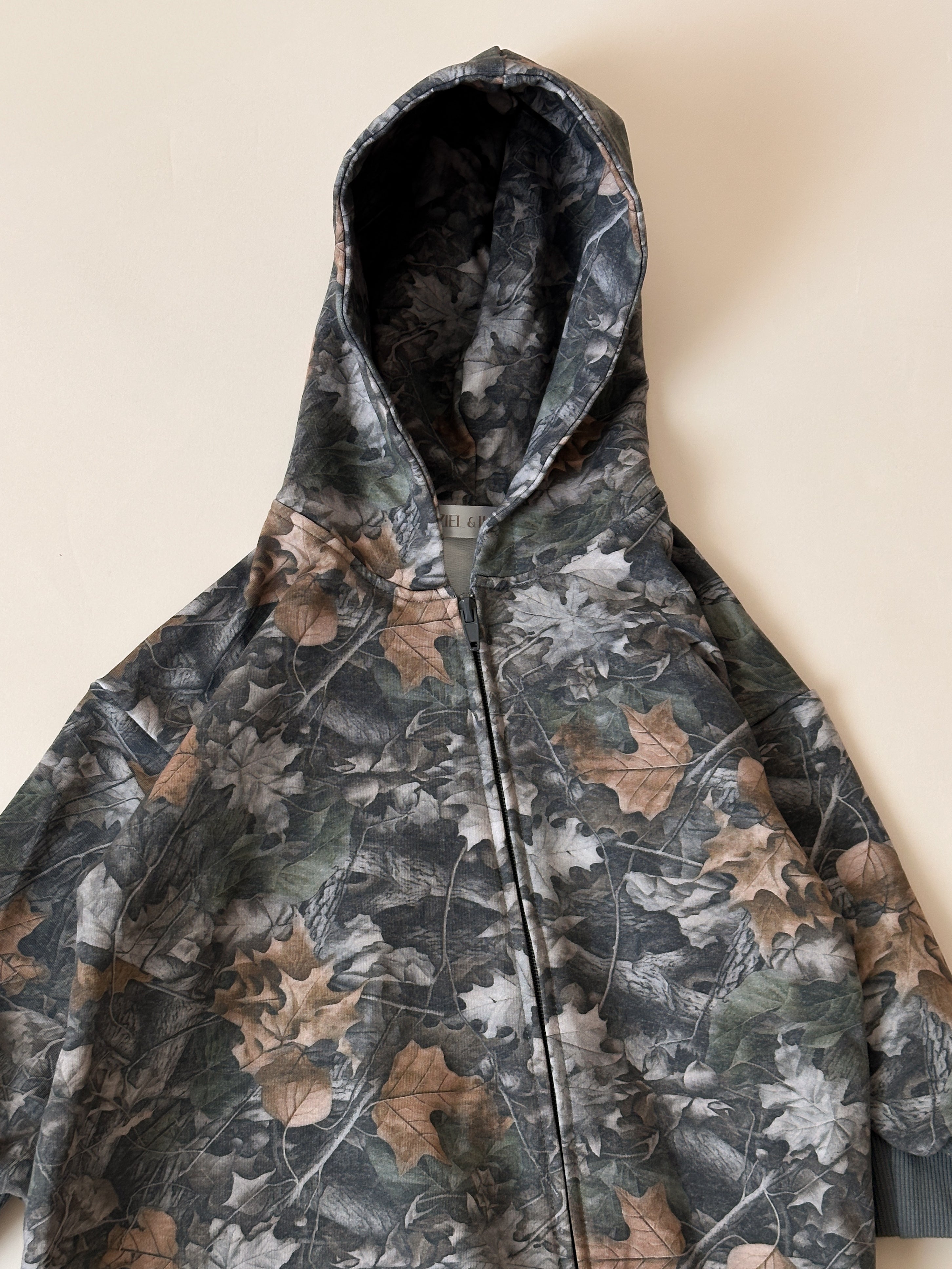 Camo zip jumpsuit for baby and toddler with leafy camouflage print and hood, perfect for stylish comfort.