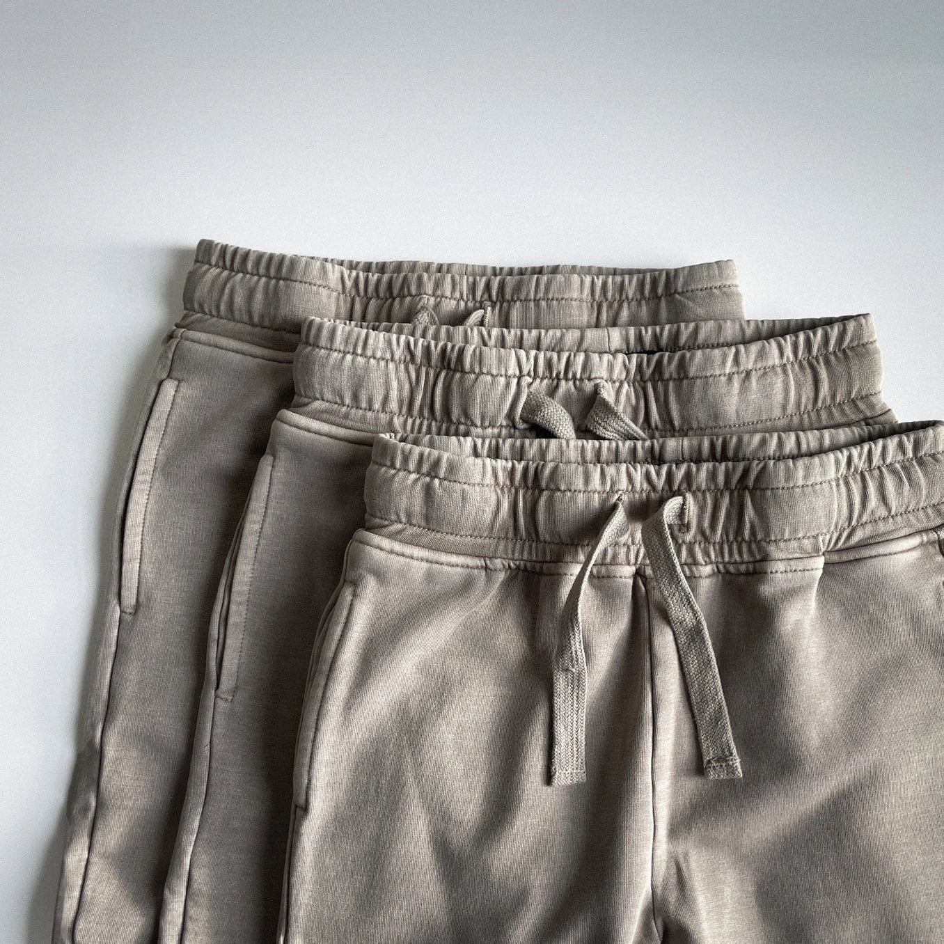 Tan acid wash joggers for kids, featuring elastic waistbands and soft French terry fabric in a vintage style.