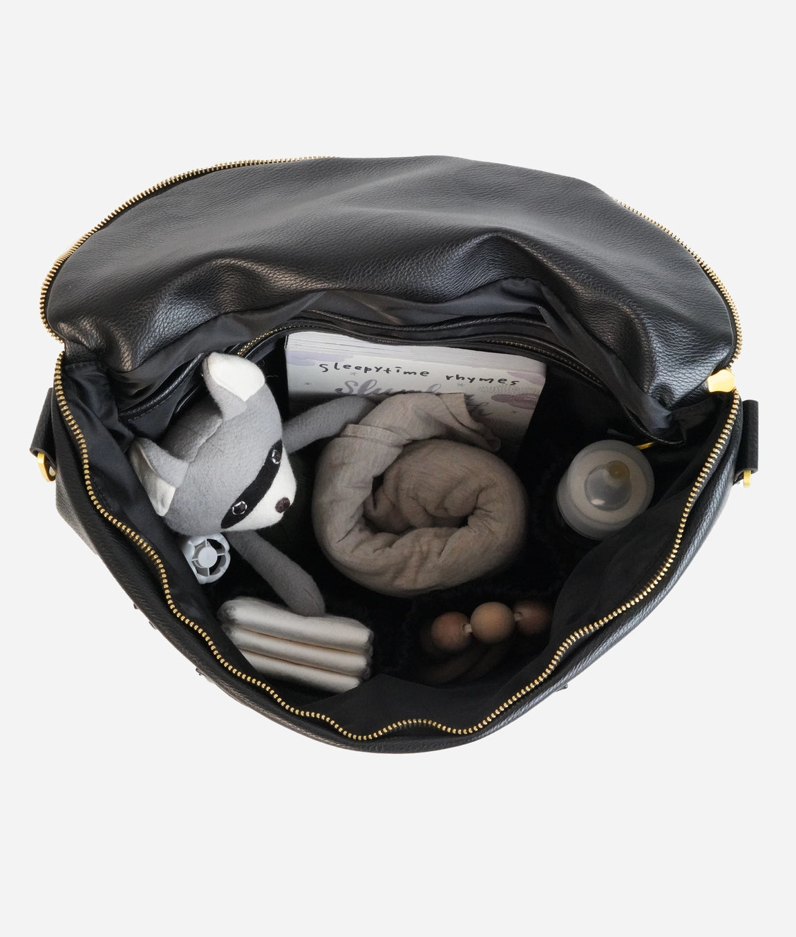Inside view of the Original Diaper Bag Backpack, showcasing organized essentials like toys, a blanket, and a book.