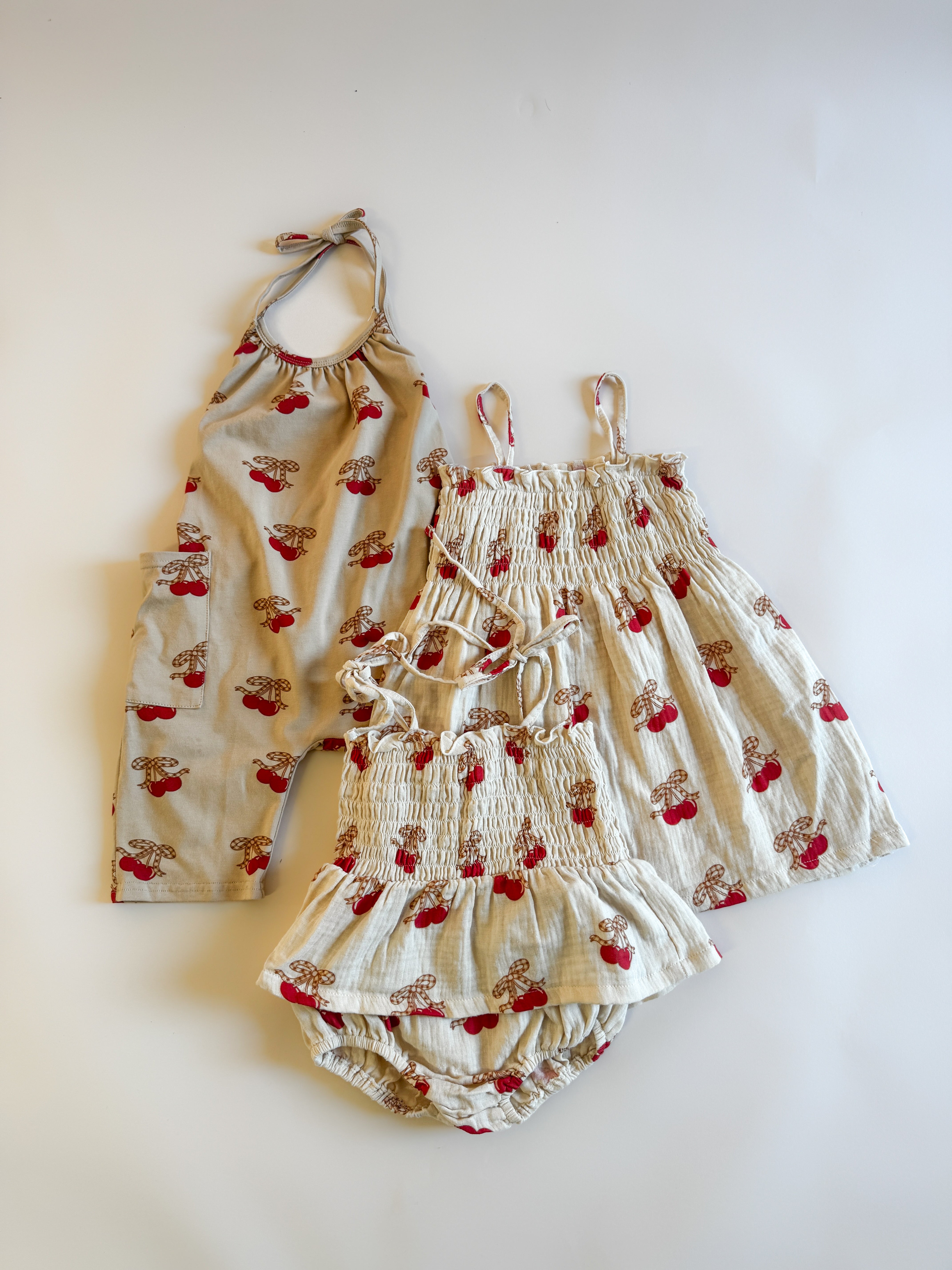Halter jumpsuit girls in playful cherry print, perfect for summer playdates and family outings.