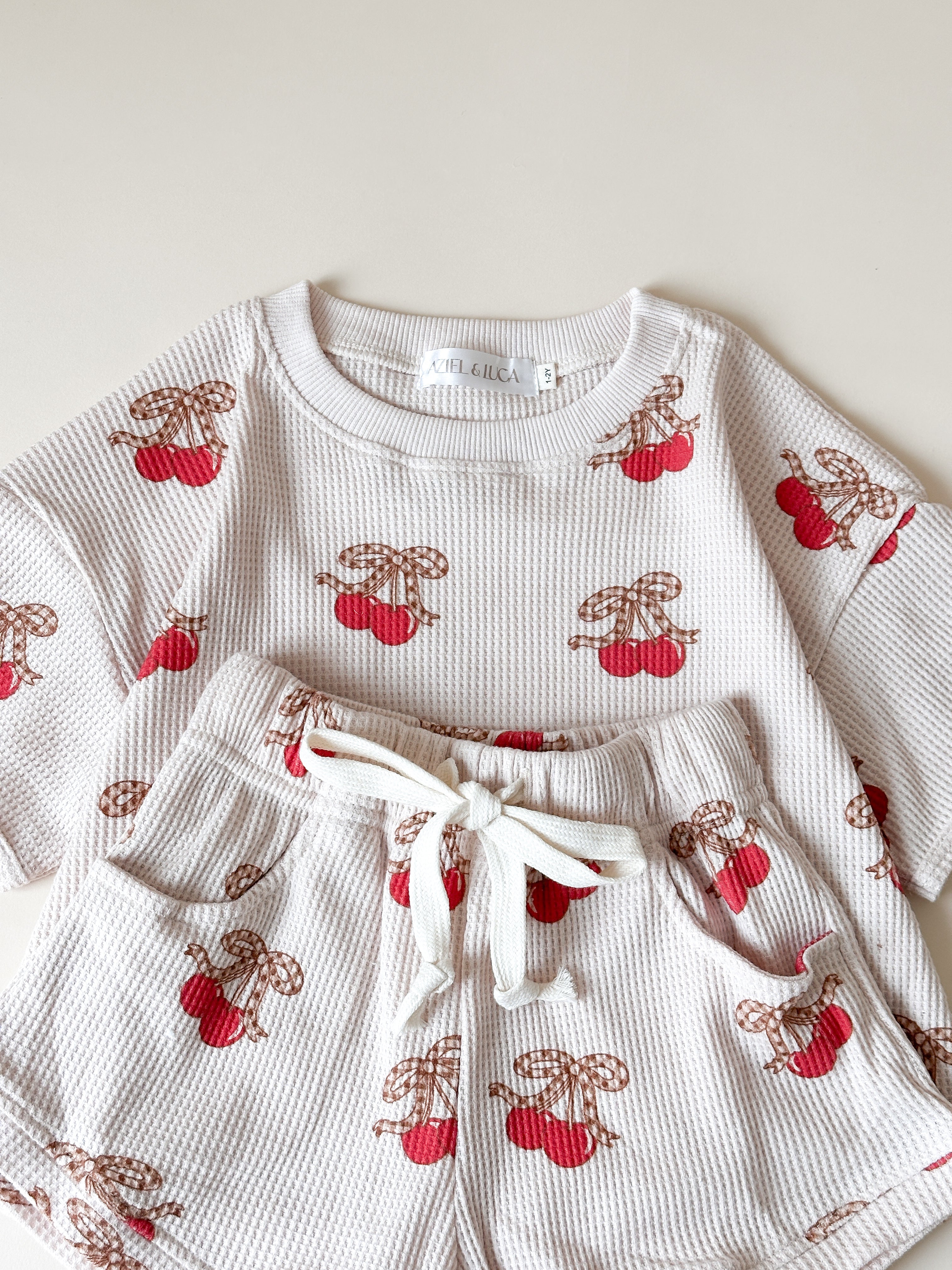 Printed waffle set for kids featuring cherry print tee and shorts, perfect for summer adventures.