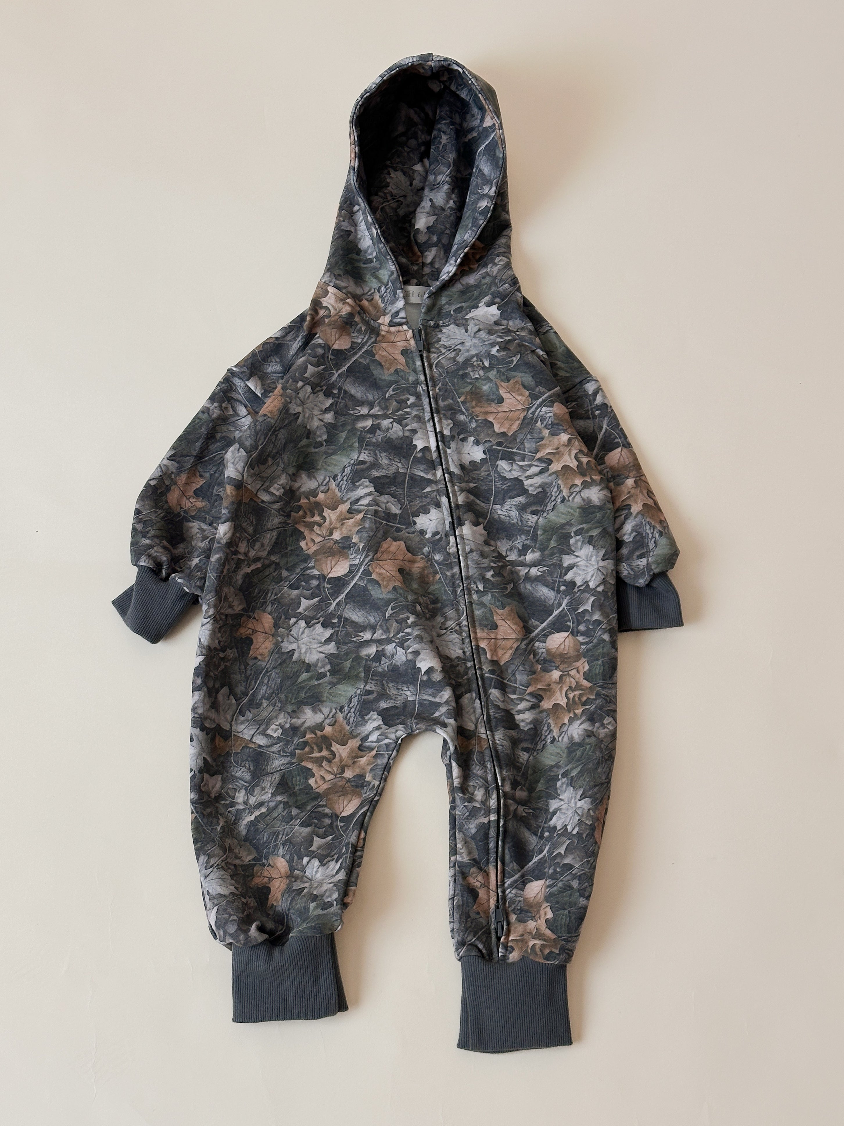 Camo zip jumpsuit for baby and toddler with hood, featuring a soft and stretchy material in neutral tones.