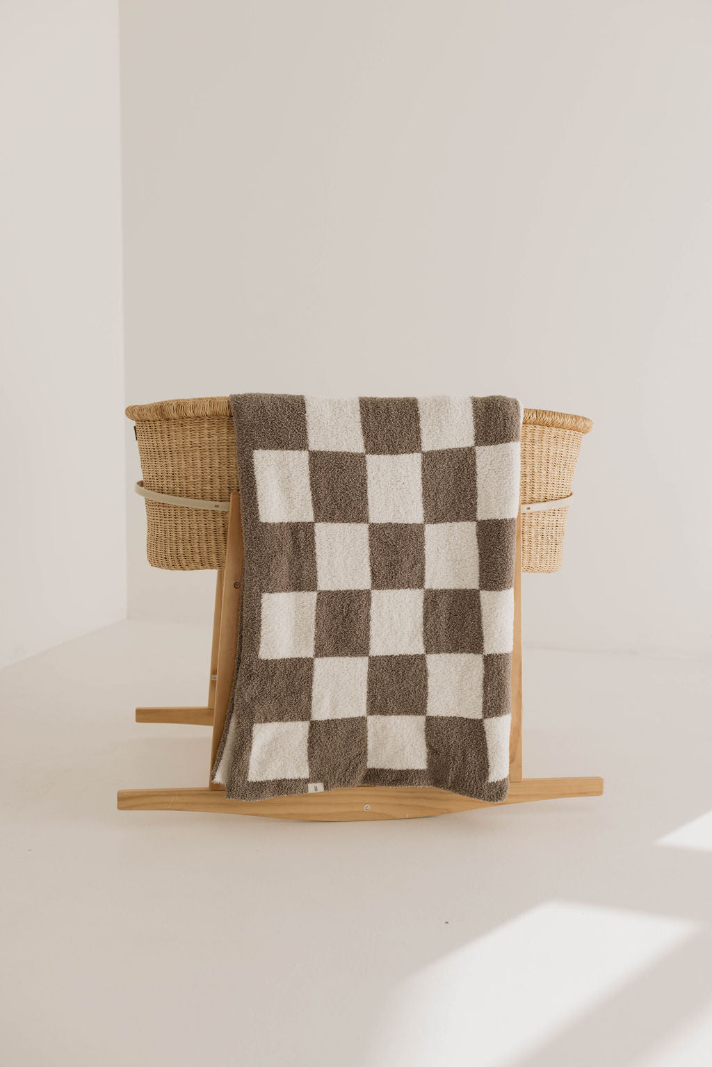 Cozy oversized plush blanket with mushroom brown checkerboard design, perfect as a modern nursery decor accent.