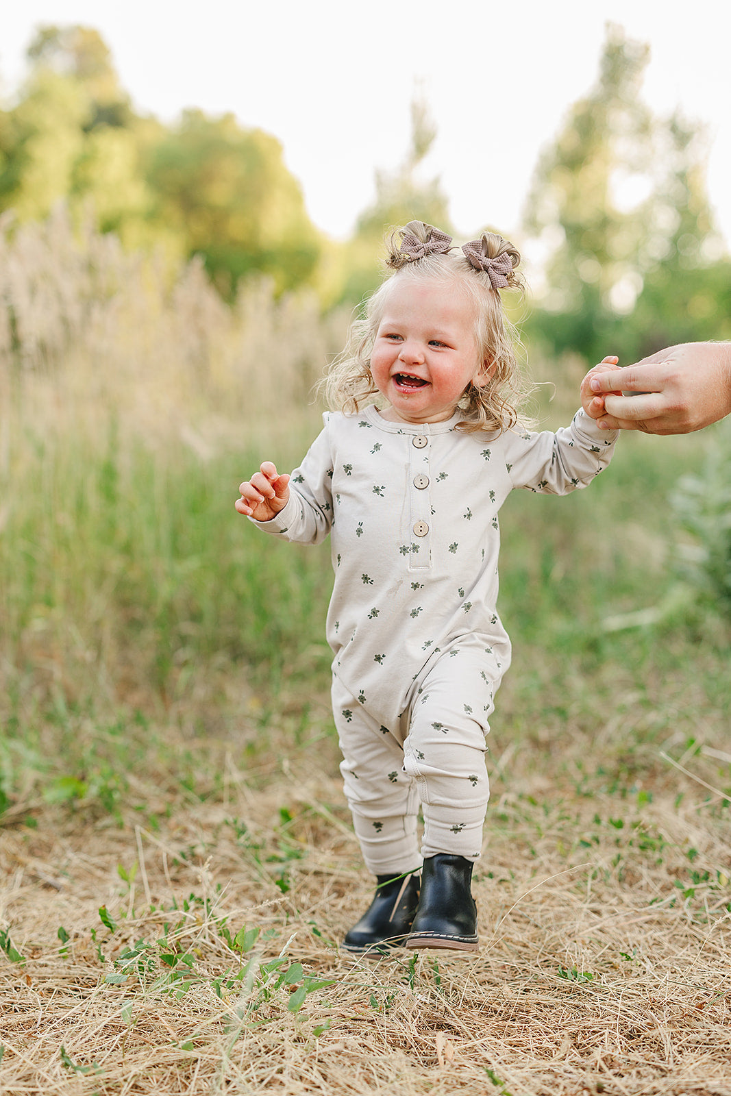 Baby girl in floral long sleeve romper running outdoors, showing playful spirit in cozy style.