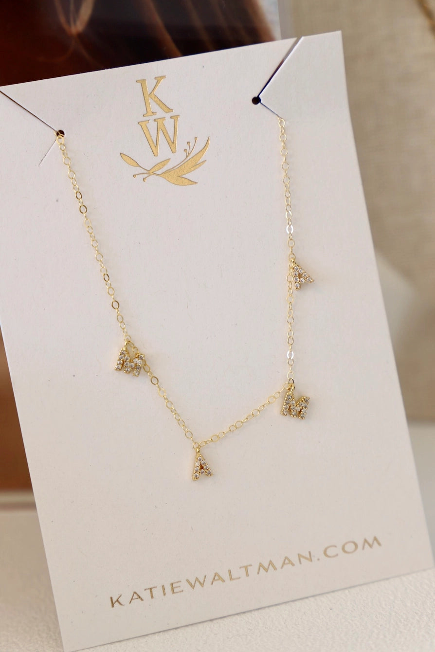 Dainty gold mama necklace on display card, featuring elegant charm design for minimalist jewelry lovers.
