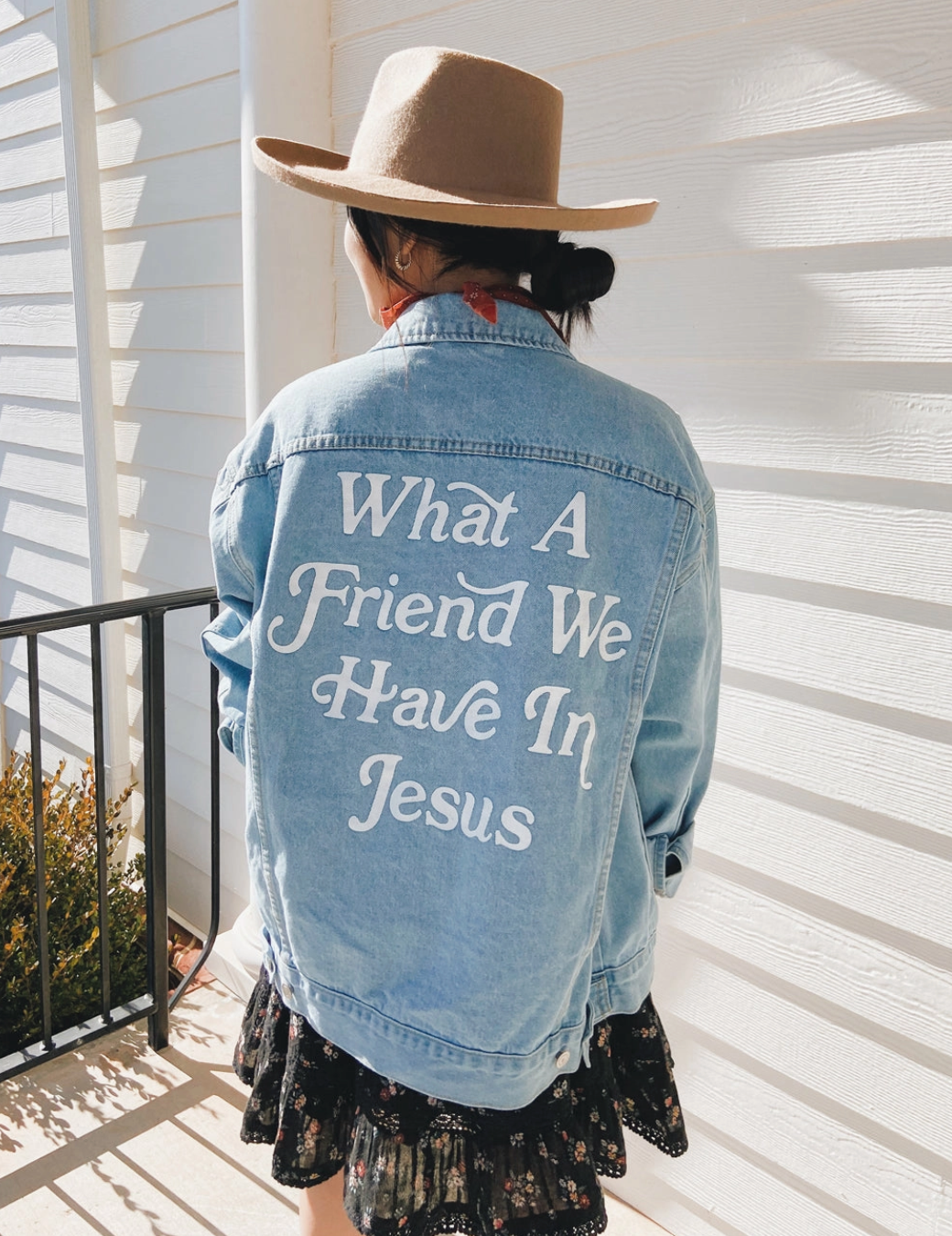 What a Friend in Jesus Denim Jacket in soft-washed denim worn by a woman, showcasing bold faith-inspired graphic.