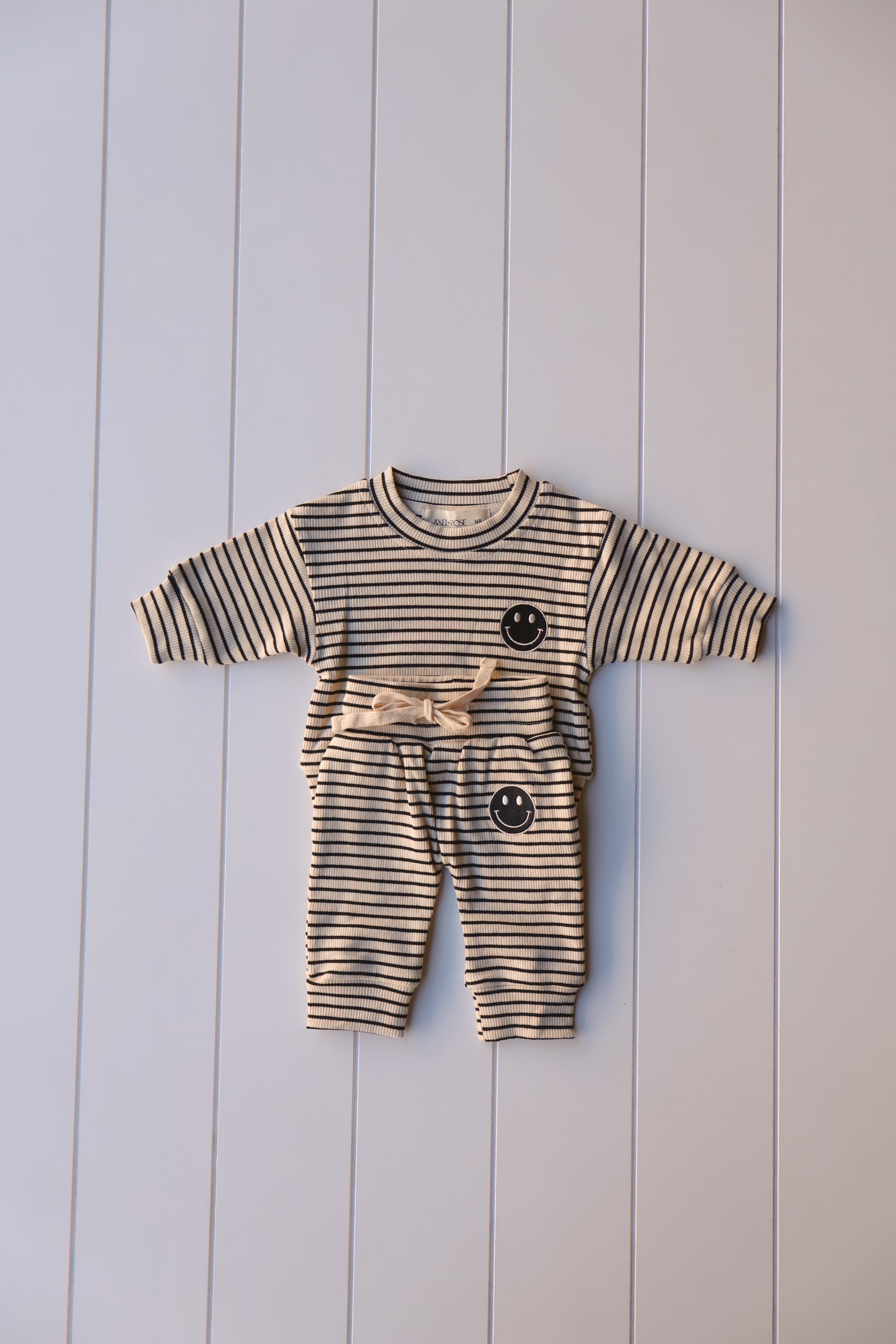 Smiley stripe set for toddlers featuring a striped tee and matching pants with a happy face graphic.
