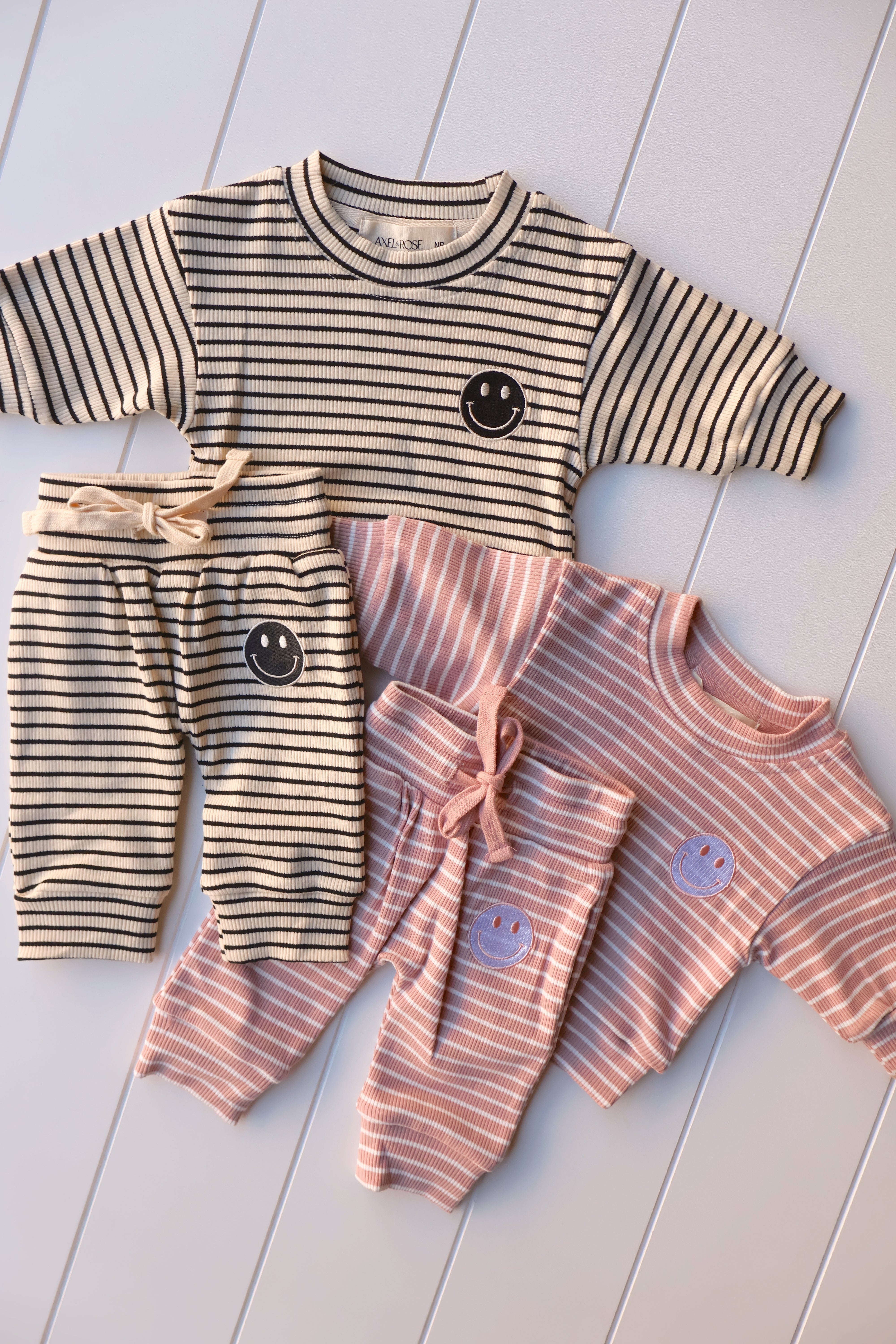 Smiley stripe set for toddlers featuring a happy face tee and matching striped shorts in beige and pink.