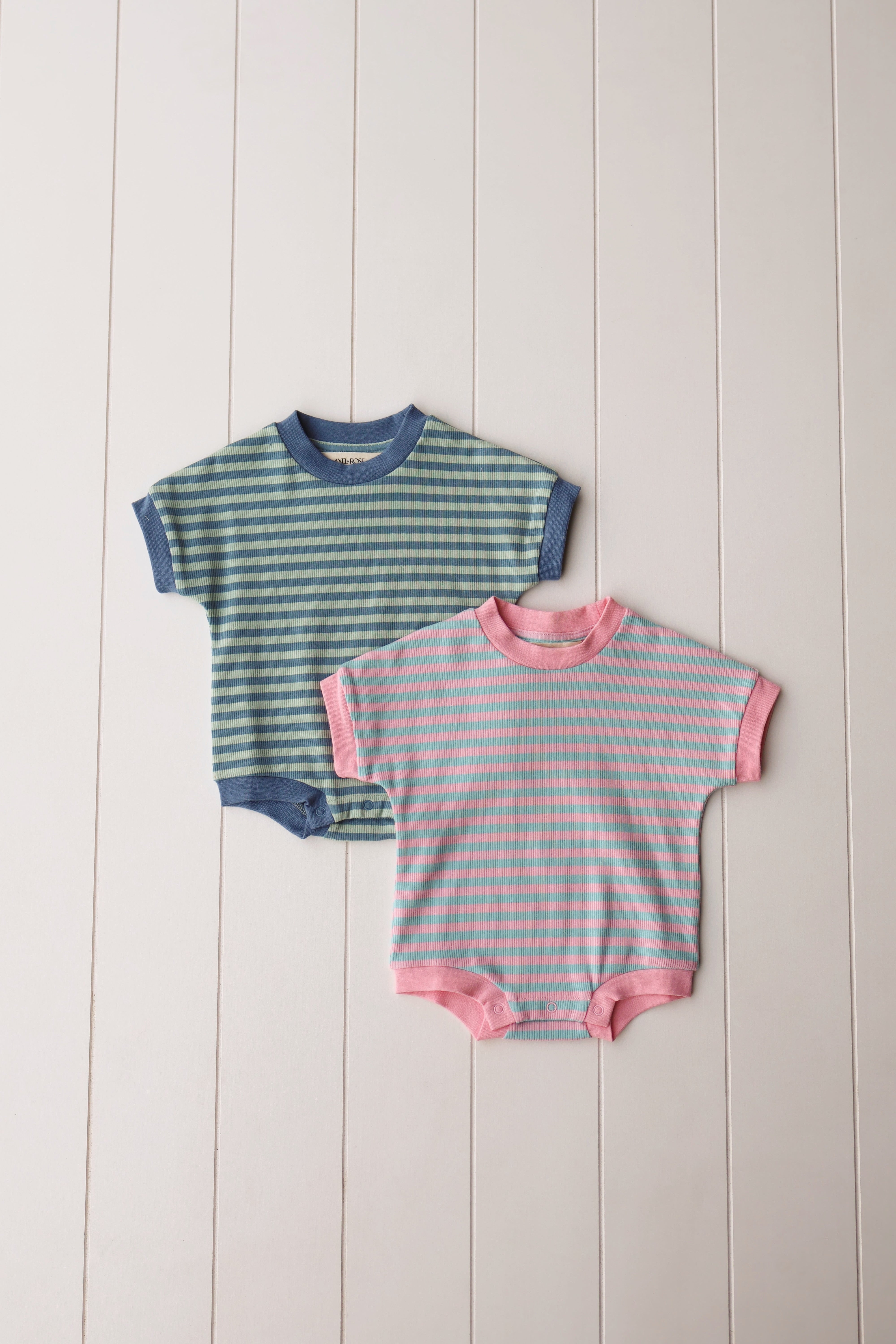 Cotton candy onesie set in pastel stripes for babies, featuring soft fabric and snap closures for comfort.