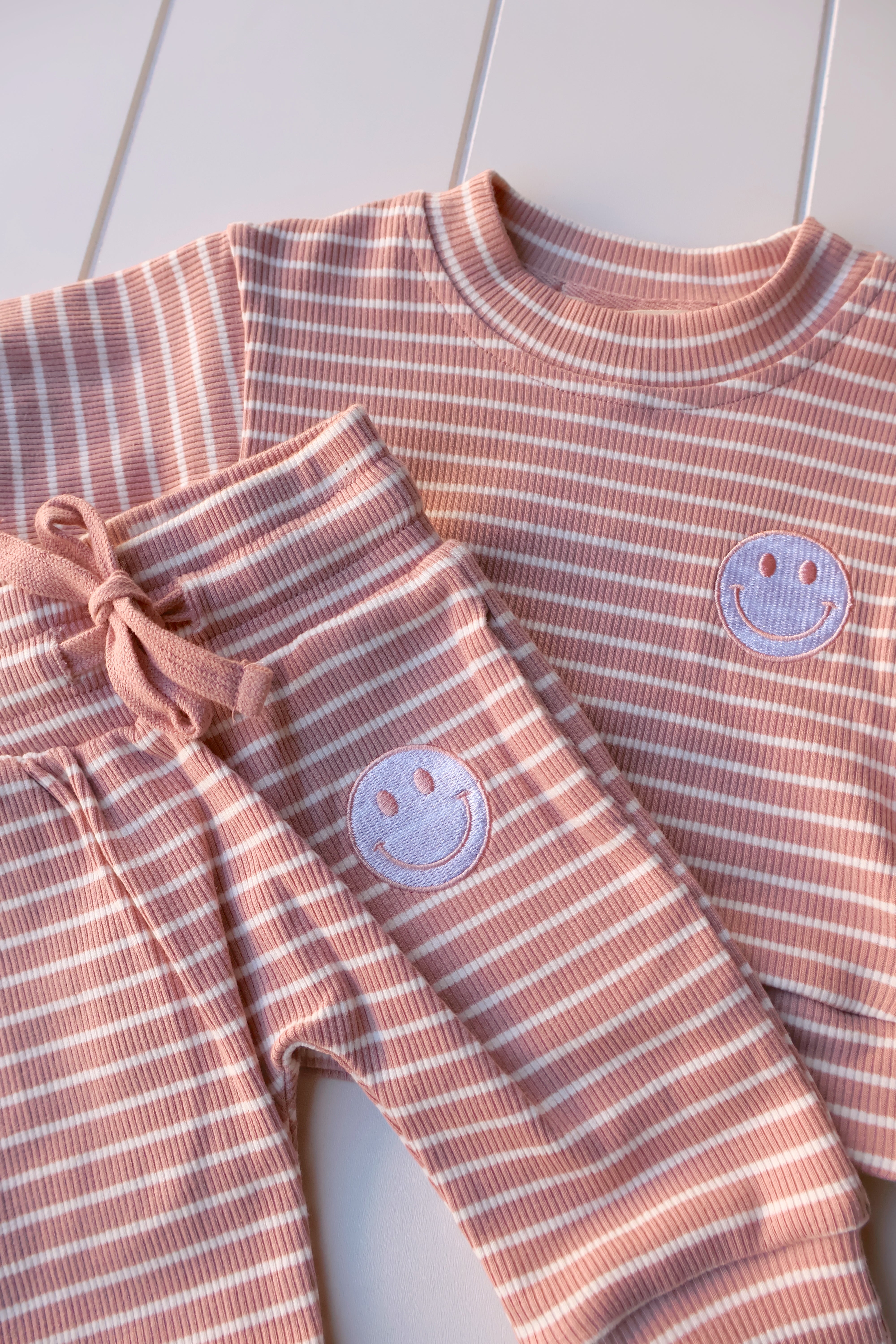 Smiley stripe set for toddlers featuring a cheerful smiley face tee and matching striped shorts.