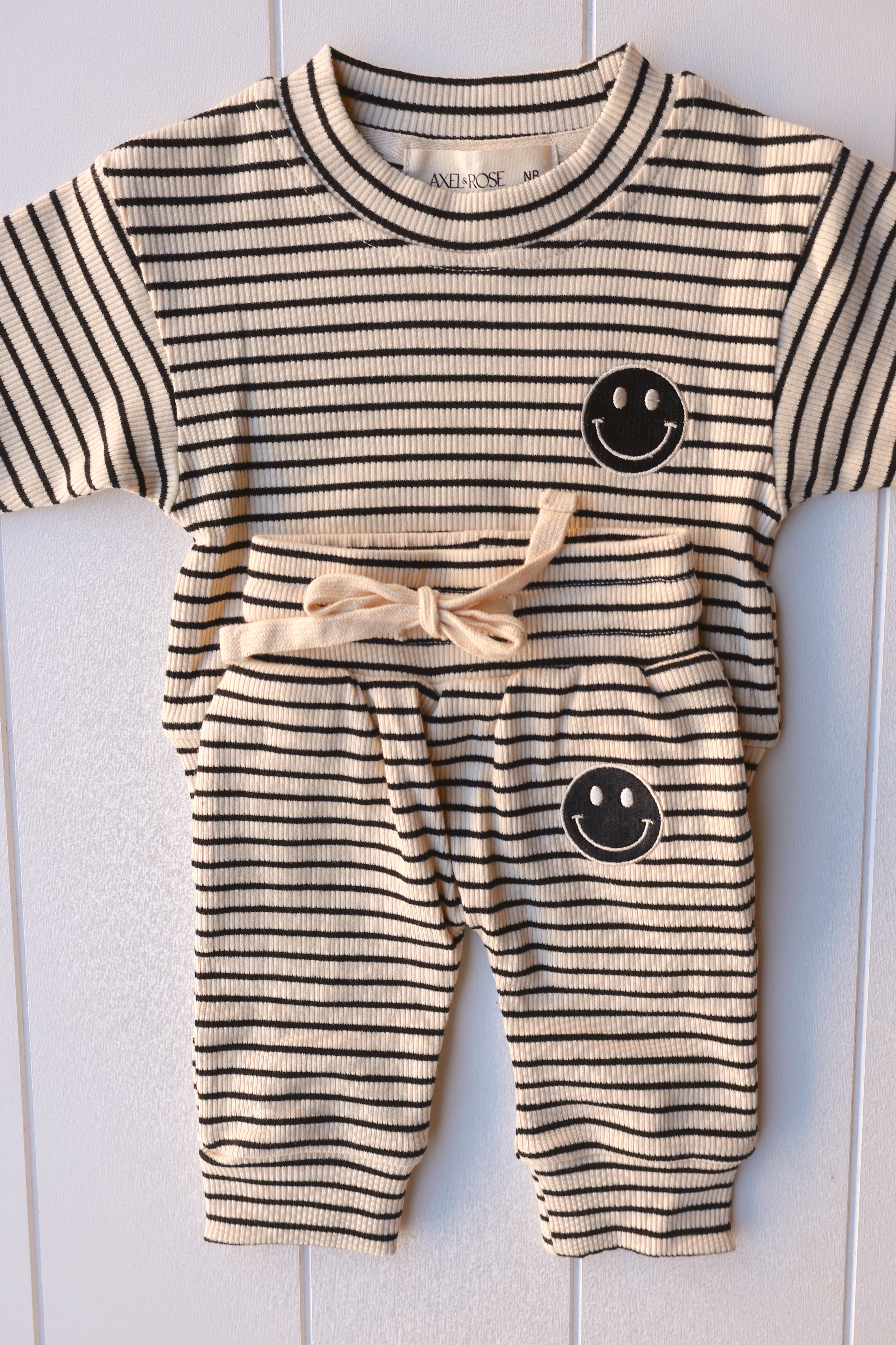 Smiley stripe set for toddlers featuring a cheerful tee and striped shorts with a smiley face graphic.
