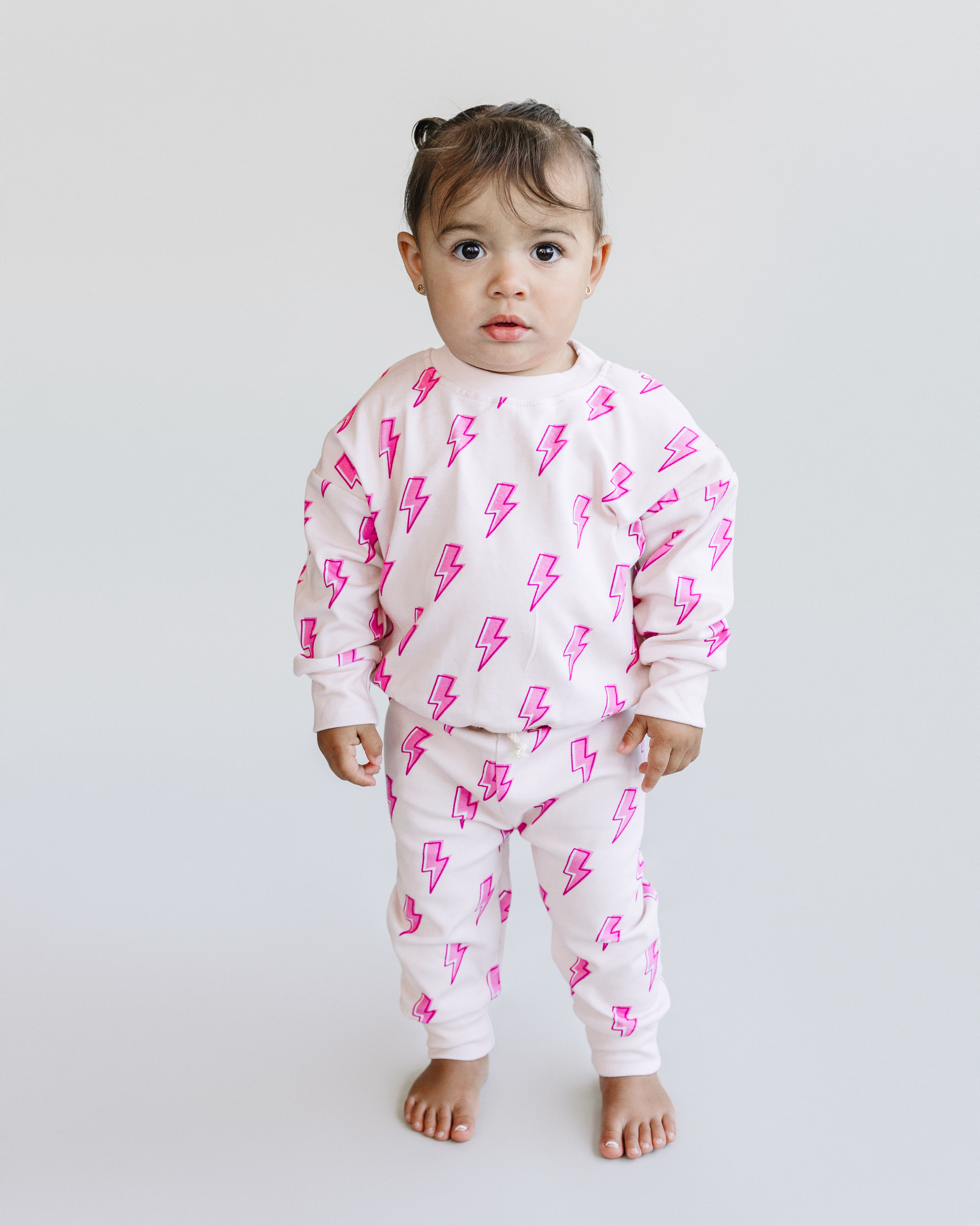 Toddler wearing pink bolt jogger set, featuring lightning bolt print, soft cotton blend for cozy and stylish play.