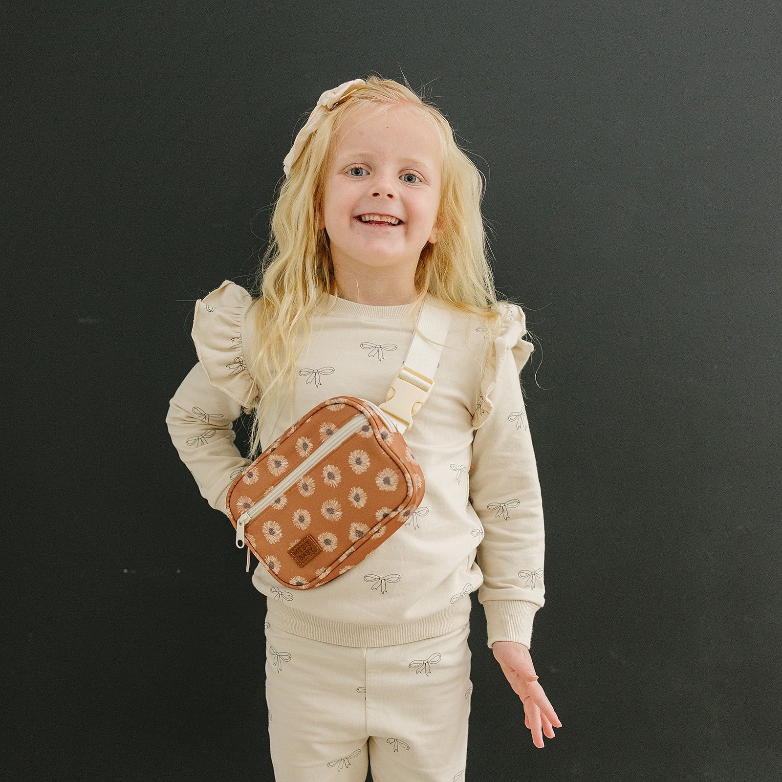 Girl smiling with a terracotta sunflower mini fanny pack, perfect for kids' adventures and stylish outings.