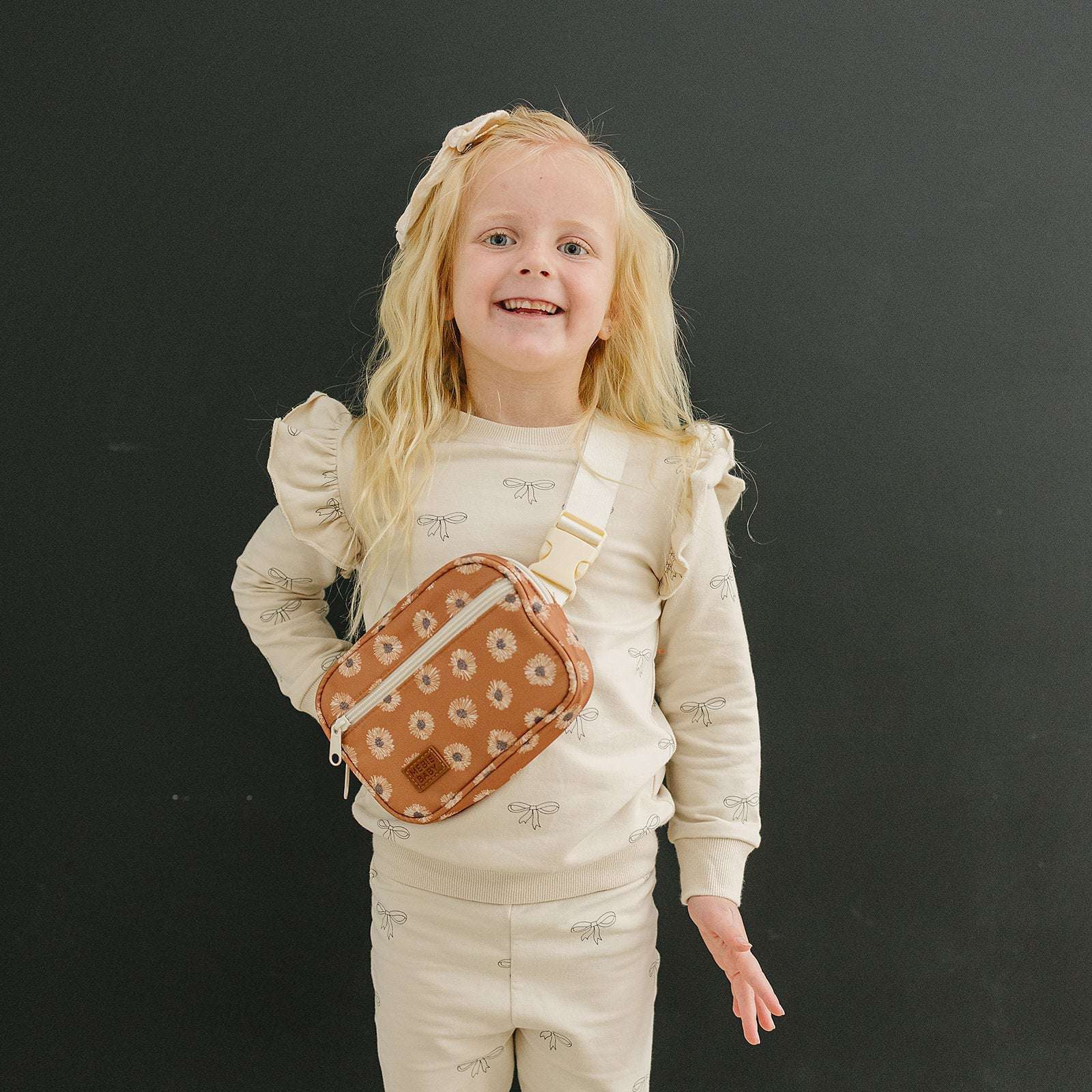 Girl smiling with a terracotta sunflower mini fanny pack, perfect for kids' adventures and stylish outings.
