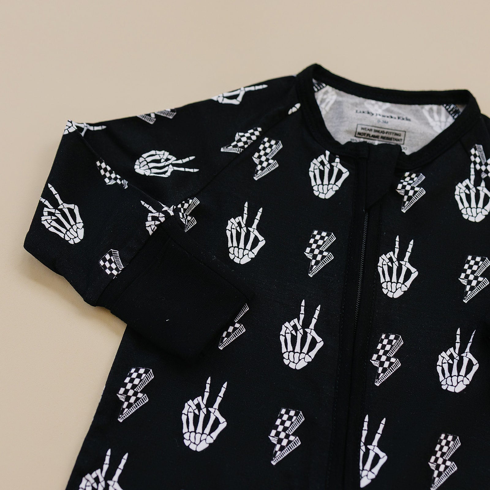 Bamboo Zip Romper Skelly Vibes featuring playful skeleton graphics in black and white.