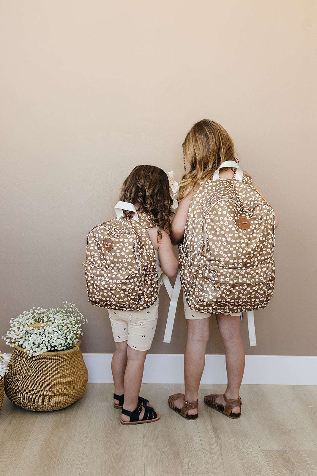 Two children with brown polka dot backpacks, showcasing stylish kids school backpacks for young students.