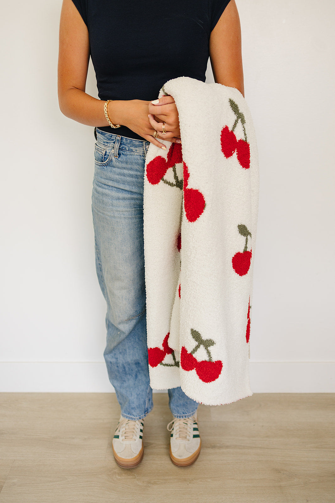 Model holding a Cherry Baby Plush Blanket featuring a playful cherry print, ideal for any nursery or cozy home.