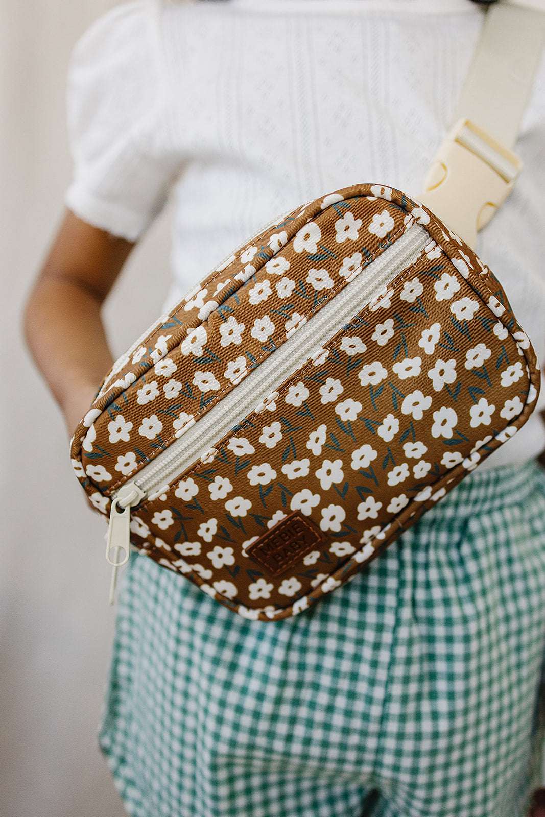 Mustard floral mini fanny pack worn by child, featuring a cheerful floral print and adjustable strap.