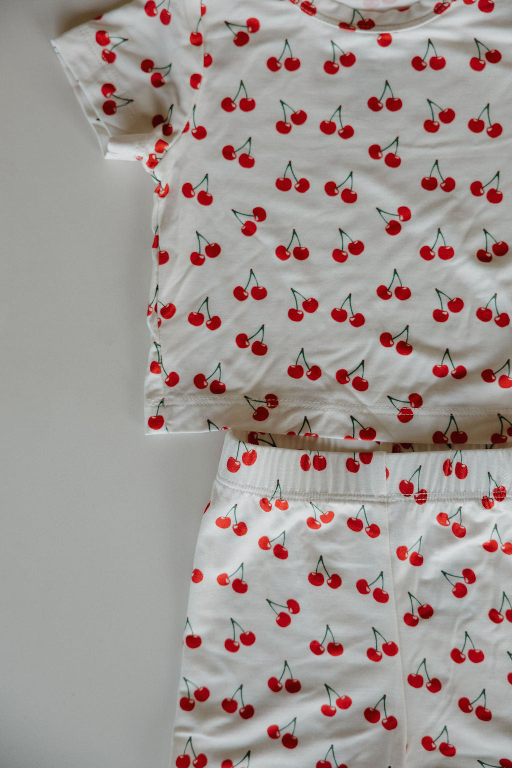 Bamboo short set featuring a playful cherry print on a white background, perfect for summer comfort.