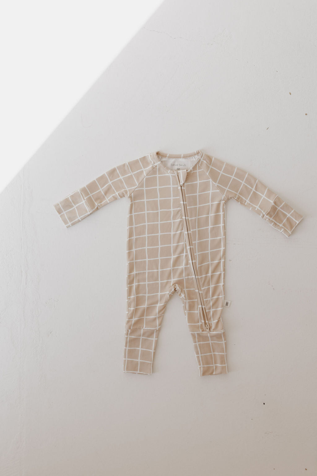 Bamboo zip pajamas in beige grid pattern for babies, featuring a double zipper and soft, stretchy fabric.