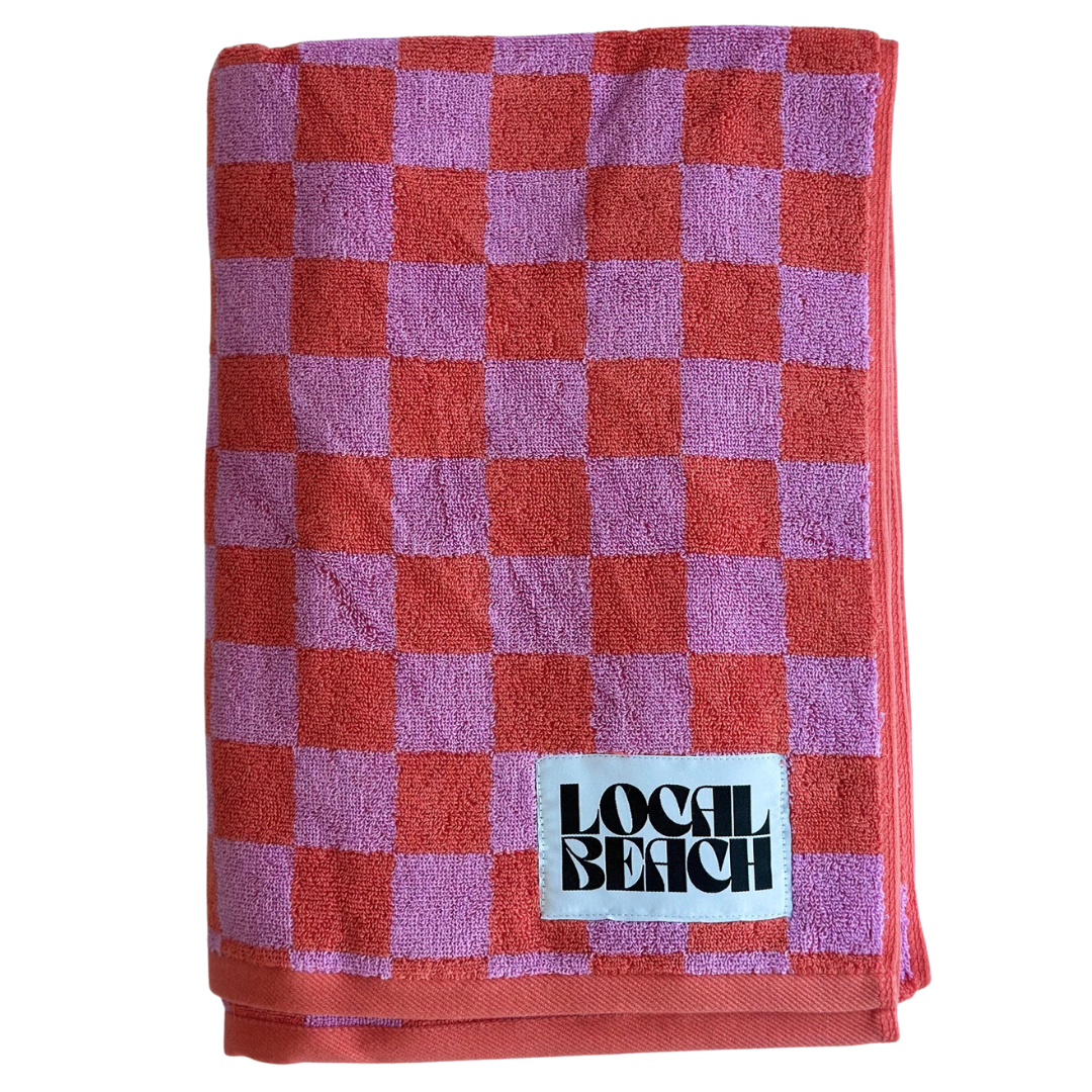 Checker beach towel in pink and coral, featuring bold checker pattern and LOCAL BEACH branding.