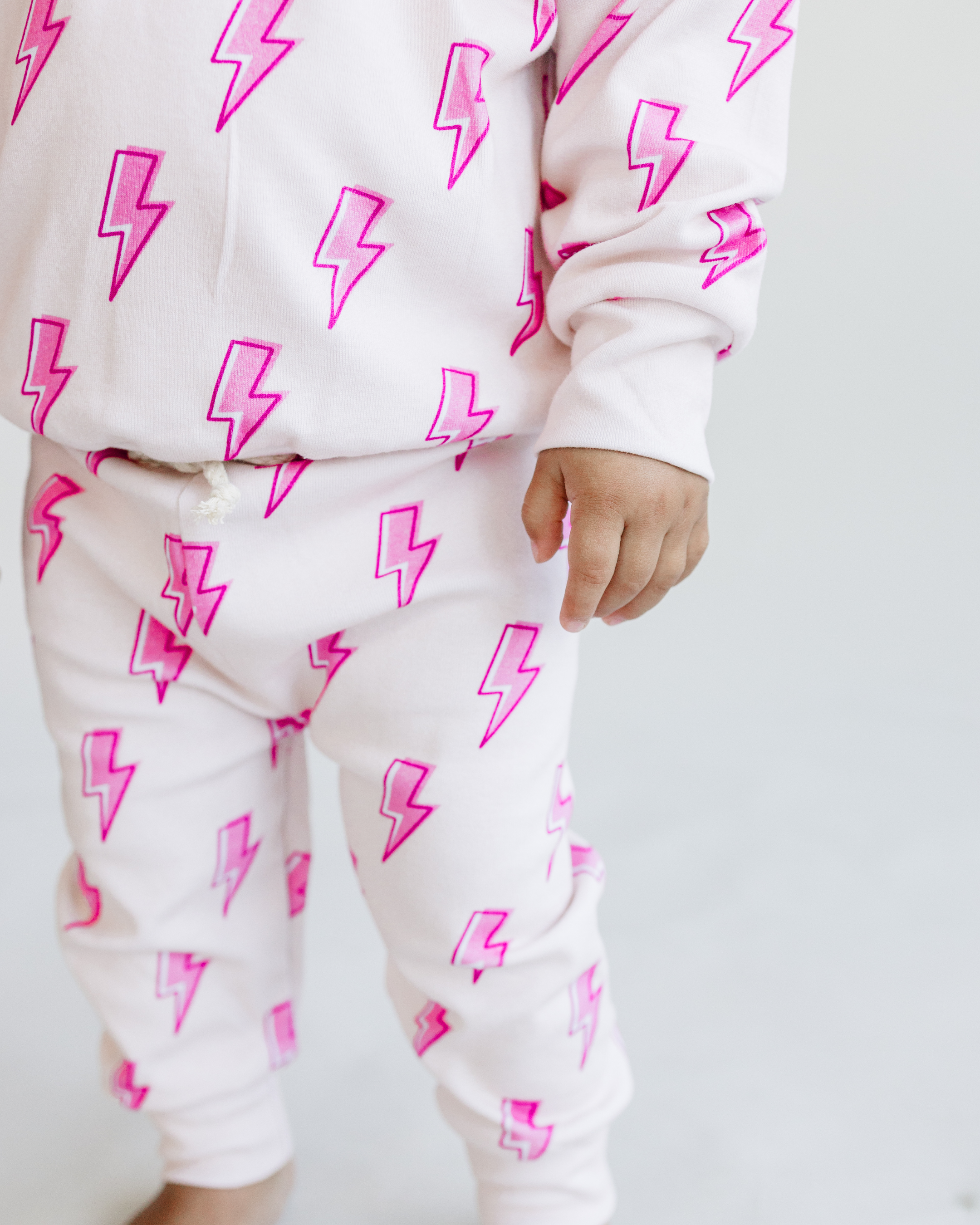 Toddler in pink bolt jogger set, featuring playful lightning bolt print on soft cotton blend fabric.
