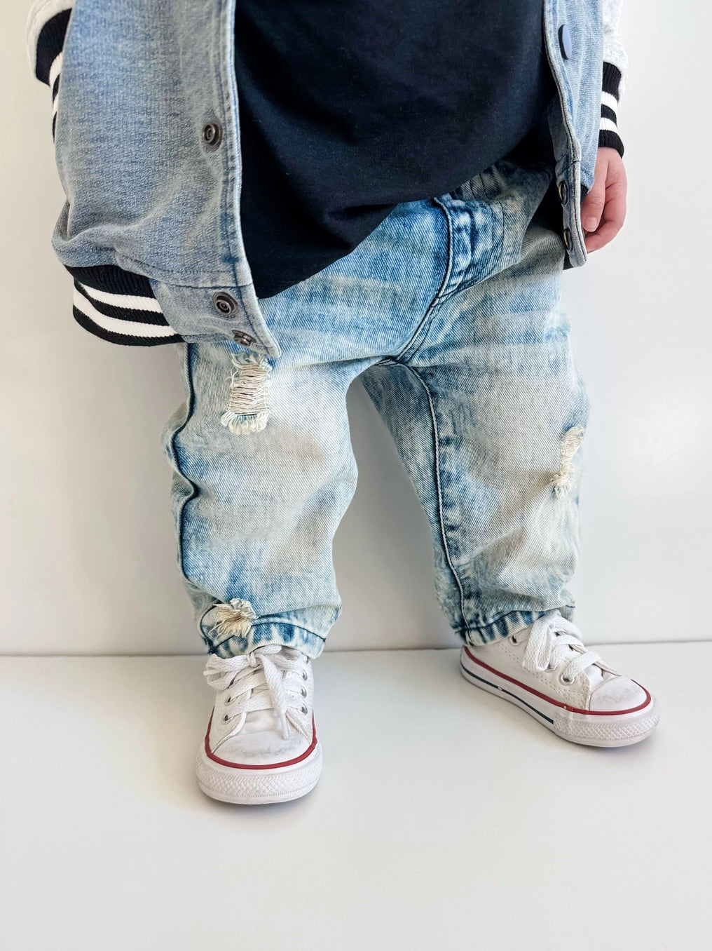 Toddler Relaxed Straight Light Acid Wash Denim Jeans styled with white sneakers and denim jacket, showcasing playful 90s vibes.