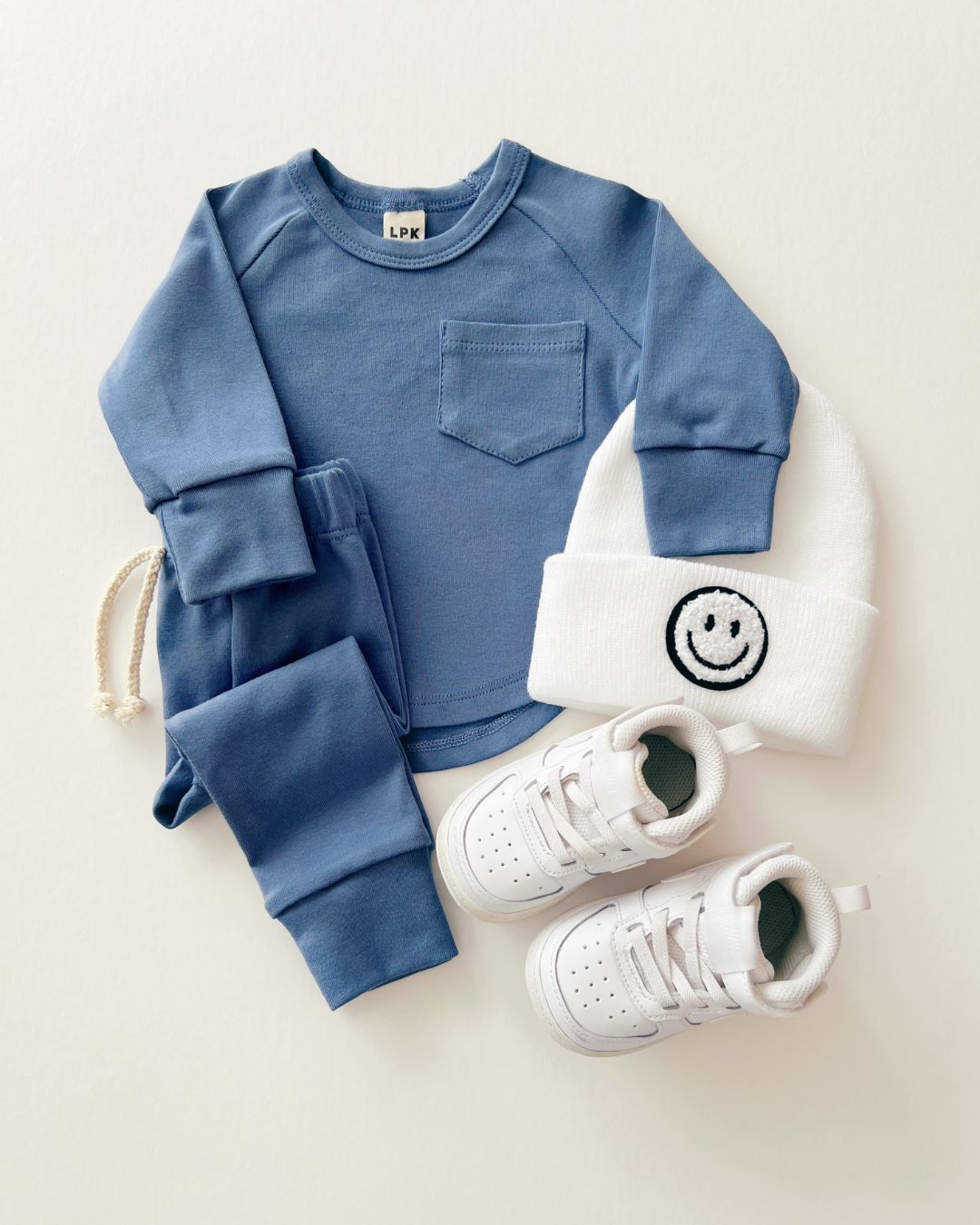 Lounge set ocean blue for kids with matching pants, sweater, smiley beanie, and stylish sneakers.