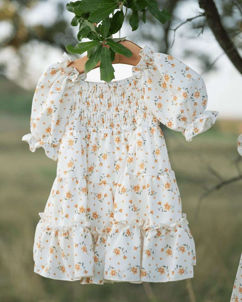 Katherine Dress in yellow floral, smocked bodice and flutter sleeves, perfect for twirling on sunny days.