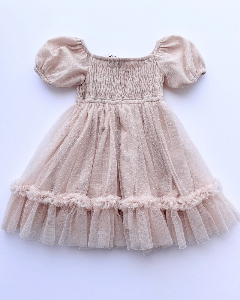Girls champagne dress with smocked bodice, dotted tulle overlay, and puffed sleeves.