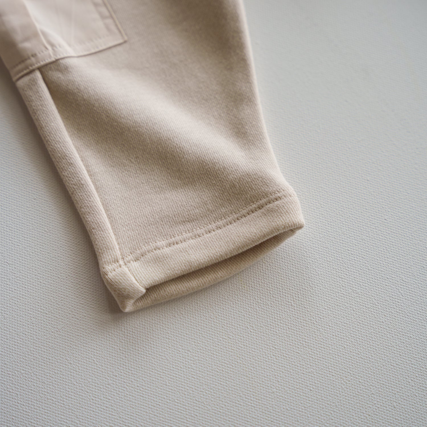 Close-up of the hem from the Cargo Wideleg Pant showcasing its relaxed neutral fabric and soft texture.
