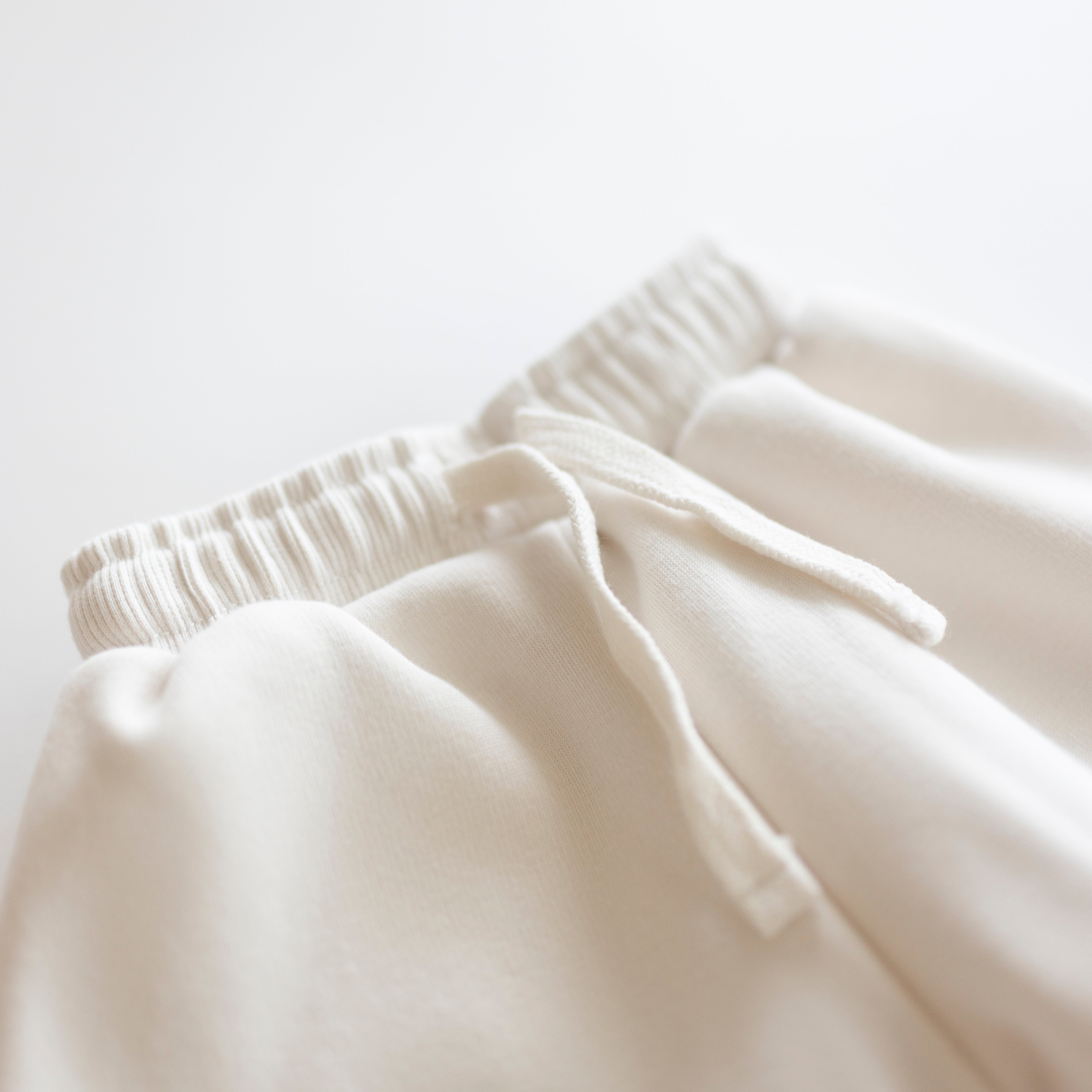 Close-up of the waistband and drawstring of the Oversized Sweatpant in soft neutral fabric.