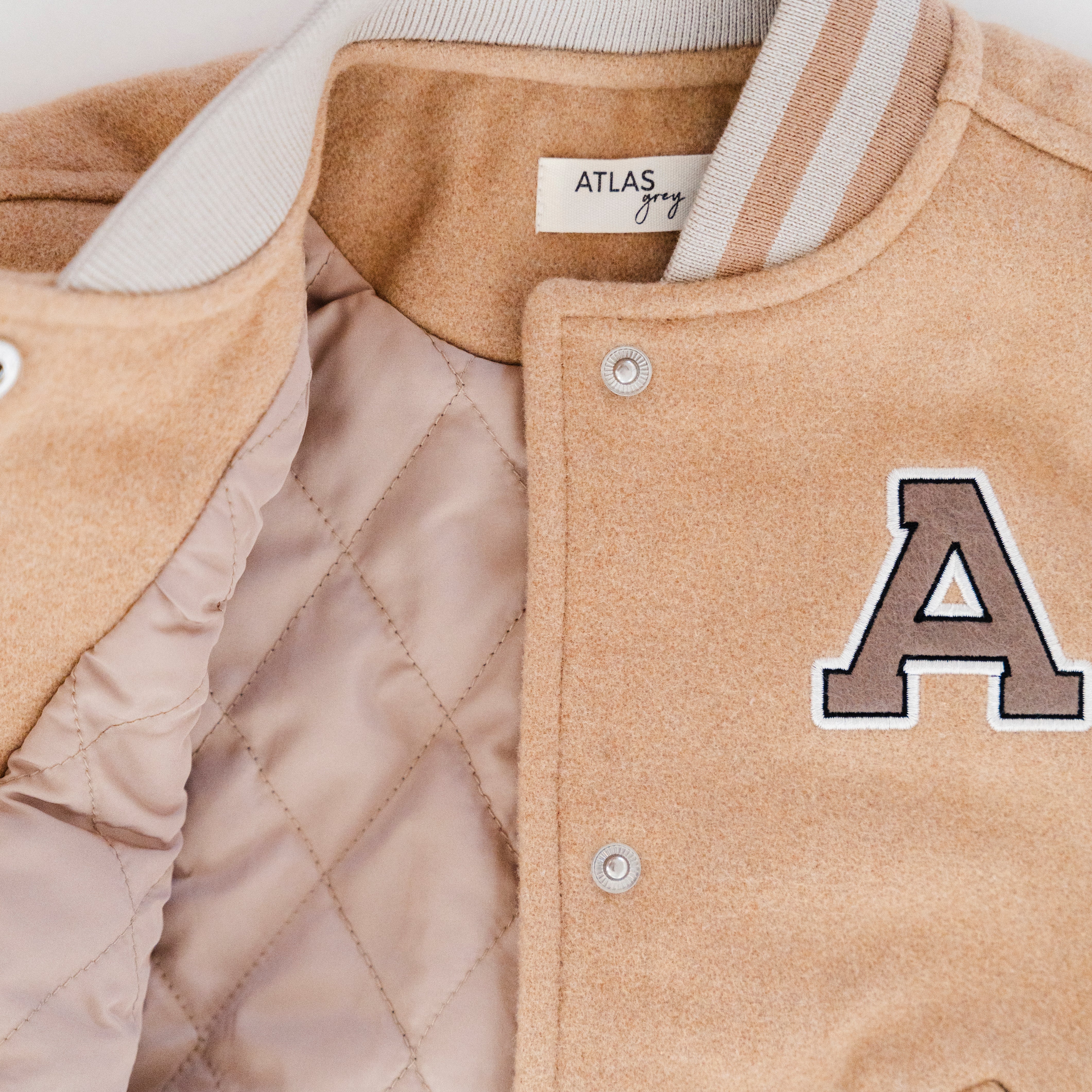 Letterman Jacket - Classic varsity outerwear for kids featuring soft tan body and quilted lining.