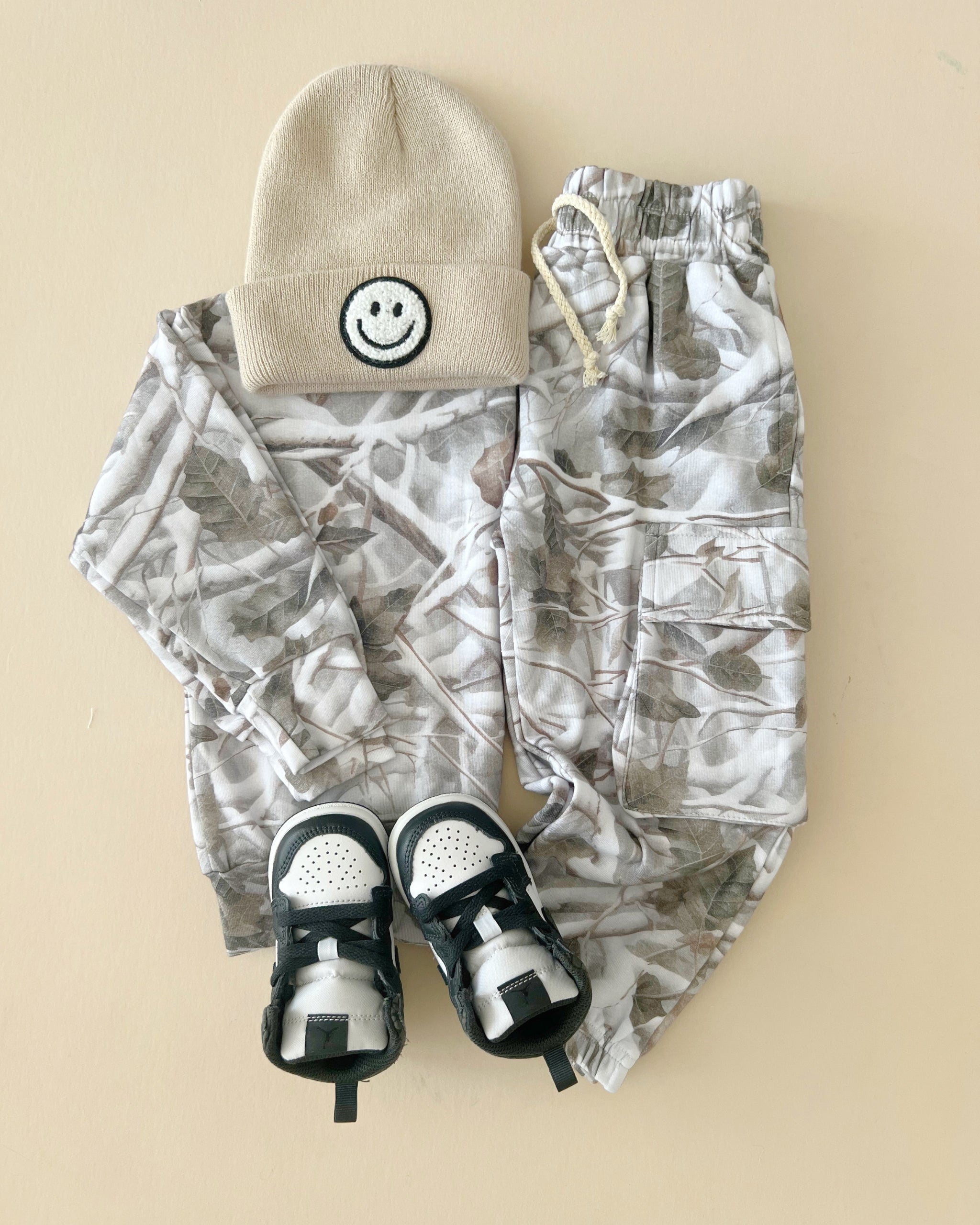Camo kids lounge set with cargo joggers and a smiley beanie, perfect for stylish kids' outfits.