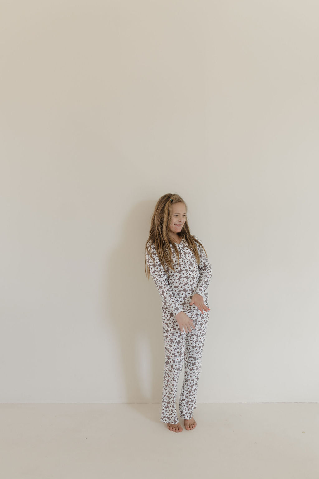Youth flare bamboo pajamas darlin displayed on a girl standing against a plain wall, showcasing floral print loungewear.