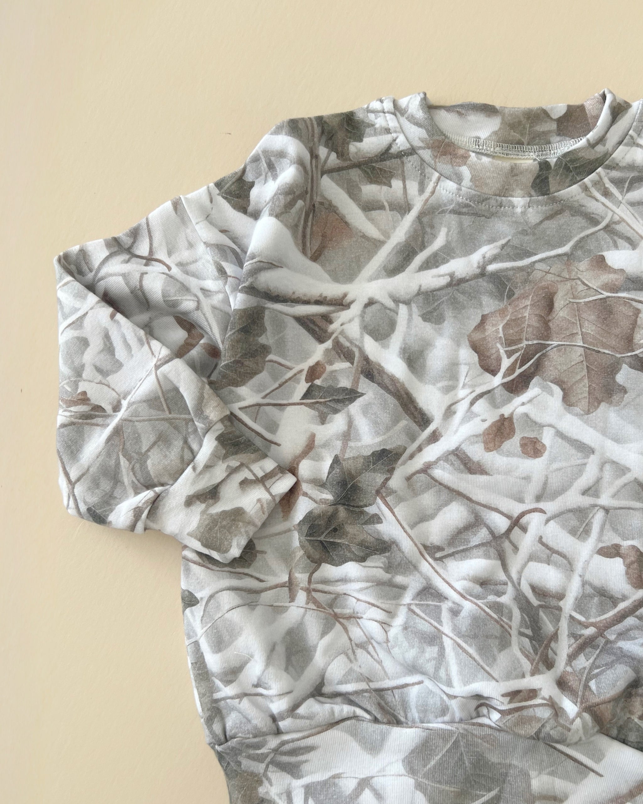 Camo kids lounge set featuring a soft pullover hoodie in a classic camo print for comfortable wear.