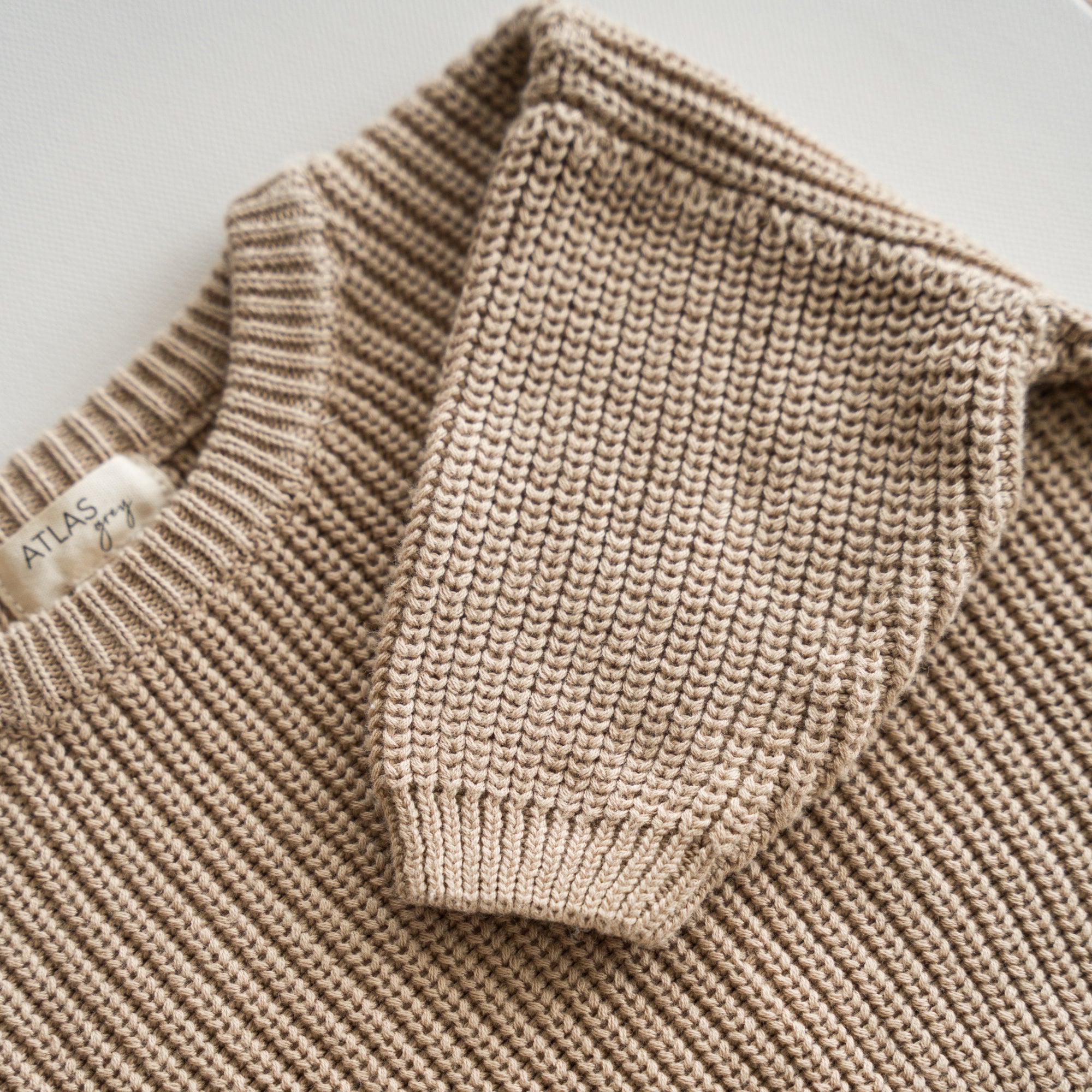 Close-up of the Organic Chunky Knit Sweater showing a soft, breathable texture in a neutral beige color.