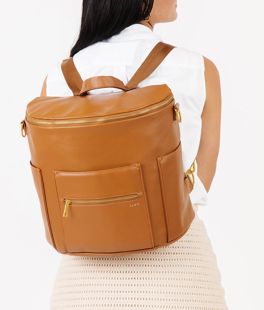 Original Diaper Bag Backpack in brown faux leather, showcasing convertible design and organizational pockets.