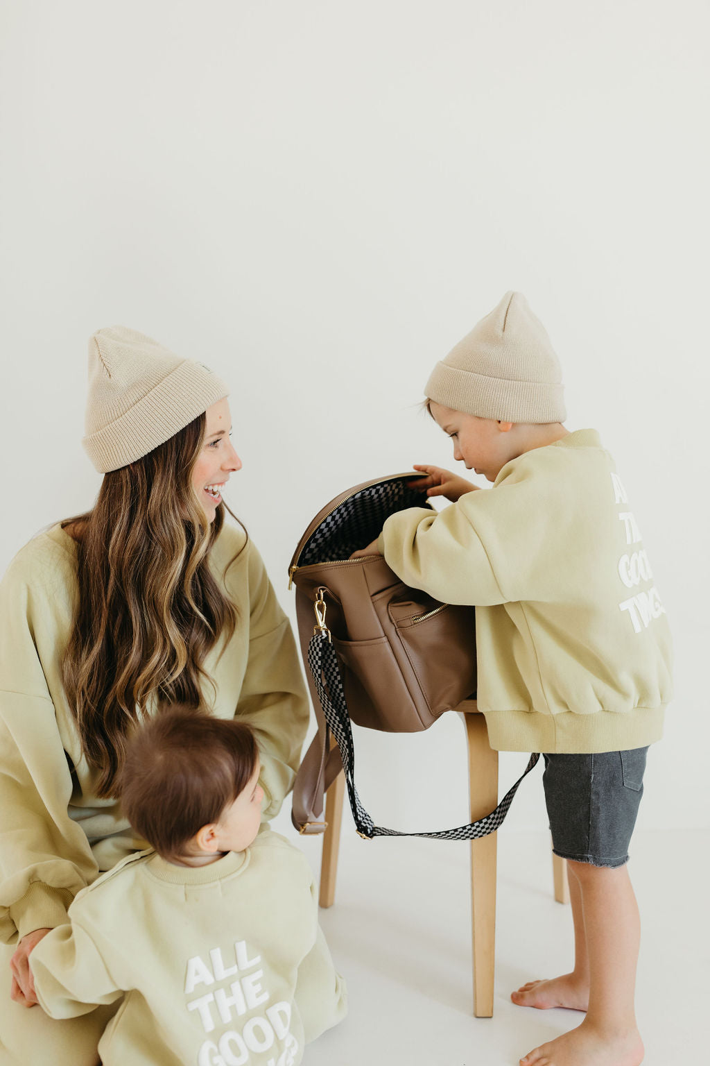 Mother and two children exploring an ff diaper bag taupe, showcasing its functionality and style.
