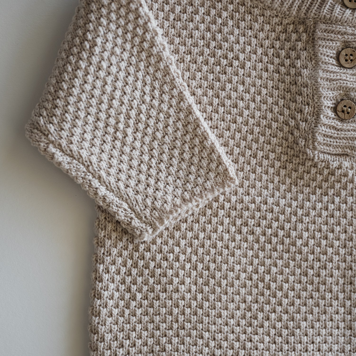 Close-up of the Organic Knit Baggy Longsleeve showing waffle texture and buttons in soft neutral color.