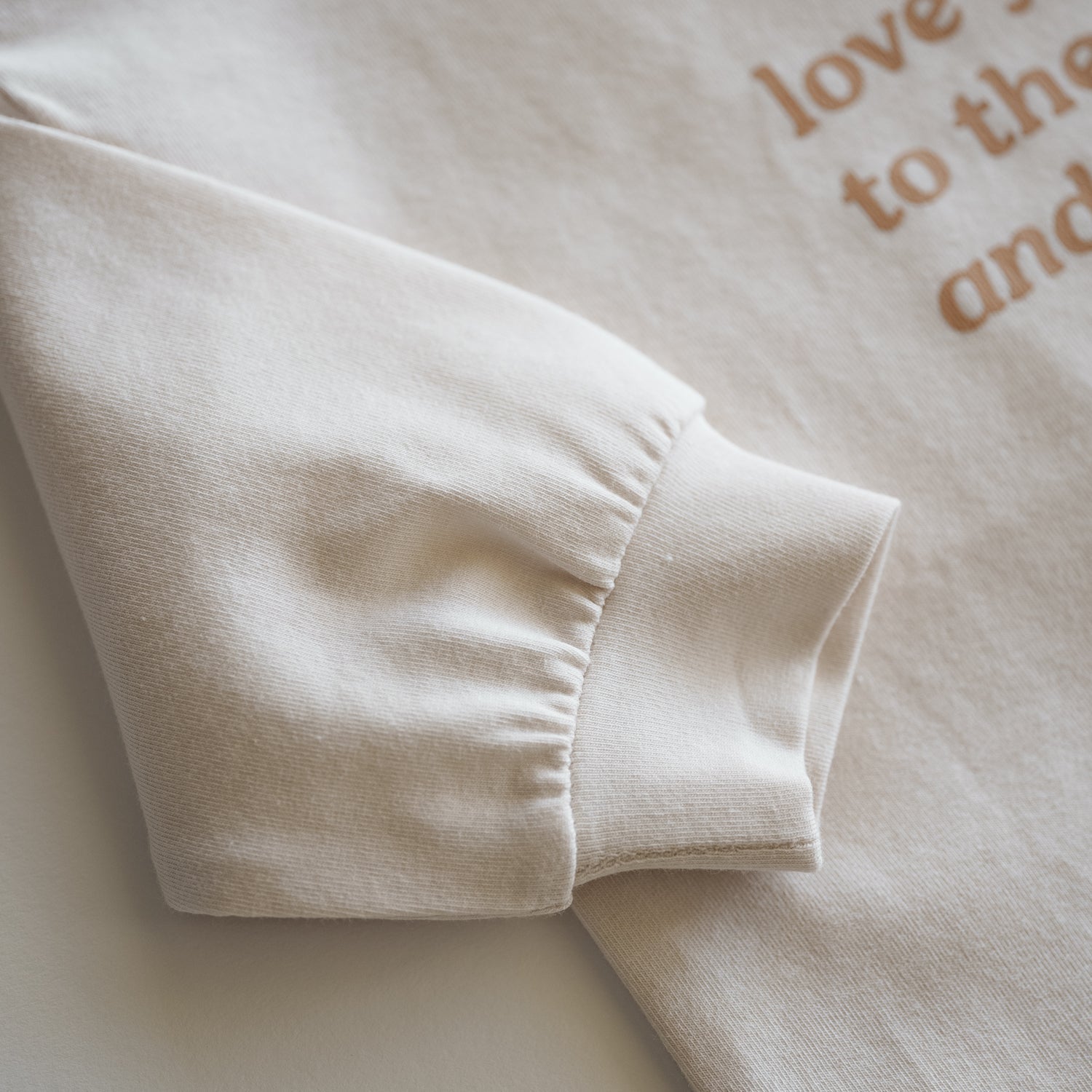 Close-up of sleeve of Love You to the Moon and Back Organic Longsleeve top in soft cotton.