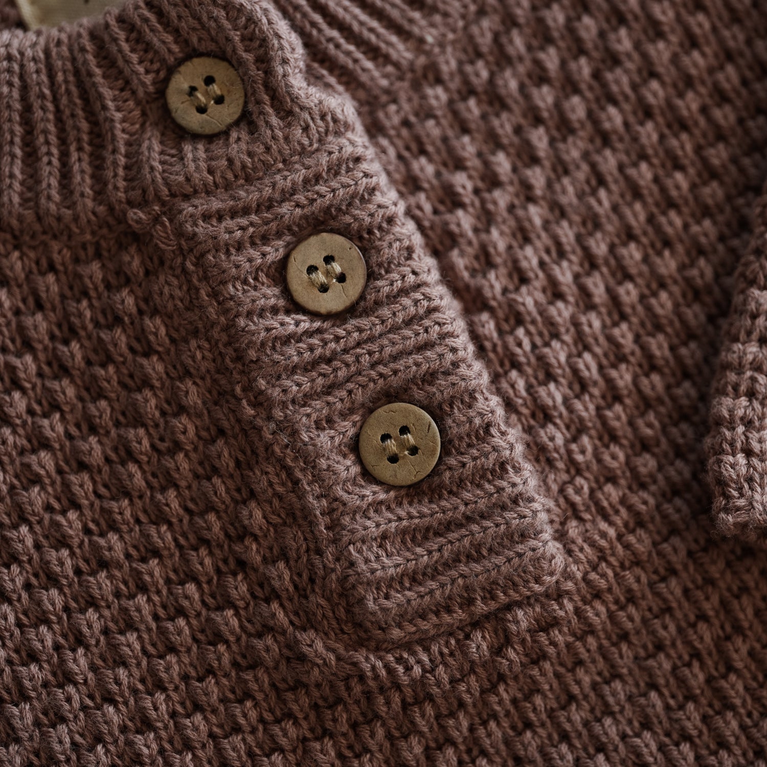 Close-up of Organic Knit Baggy Longsleeve showing waffle texture and buttons in brown color.