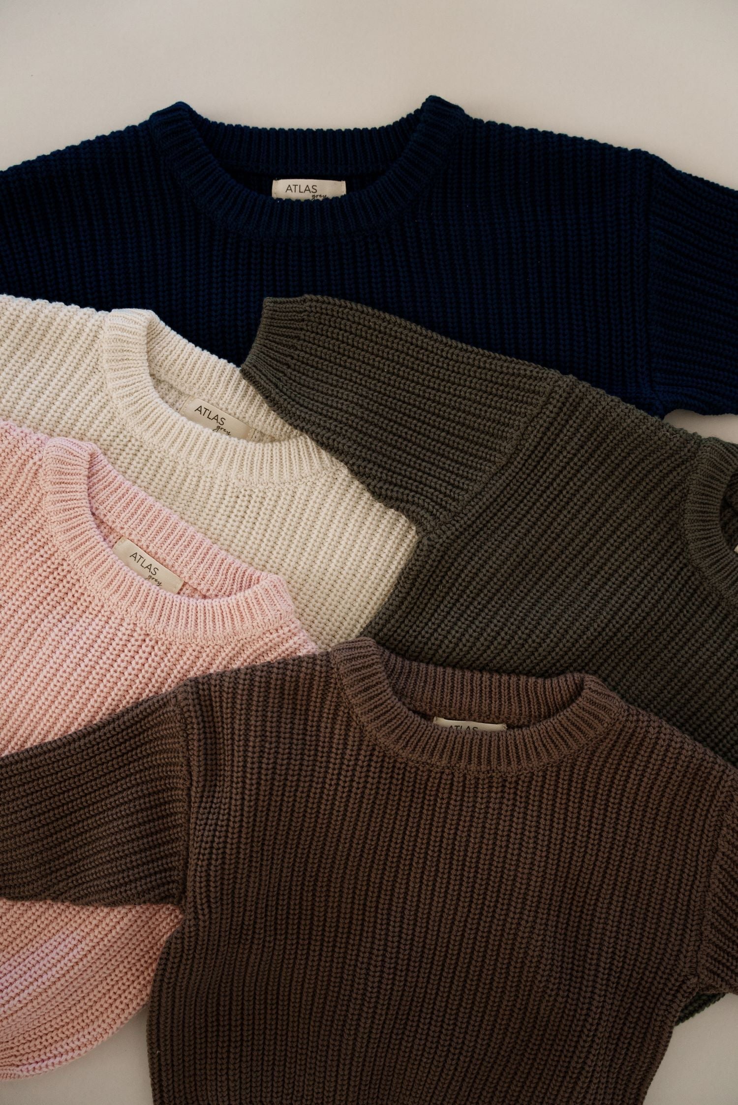 Organic Chunky Knit Sweater in various colors: navy, blush, white, olive, and chocolate for babies and kids.
